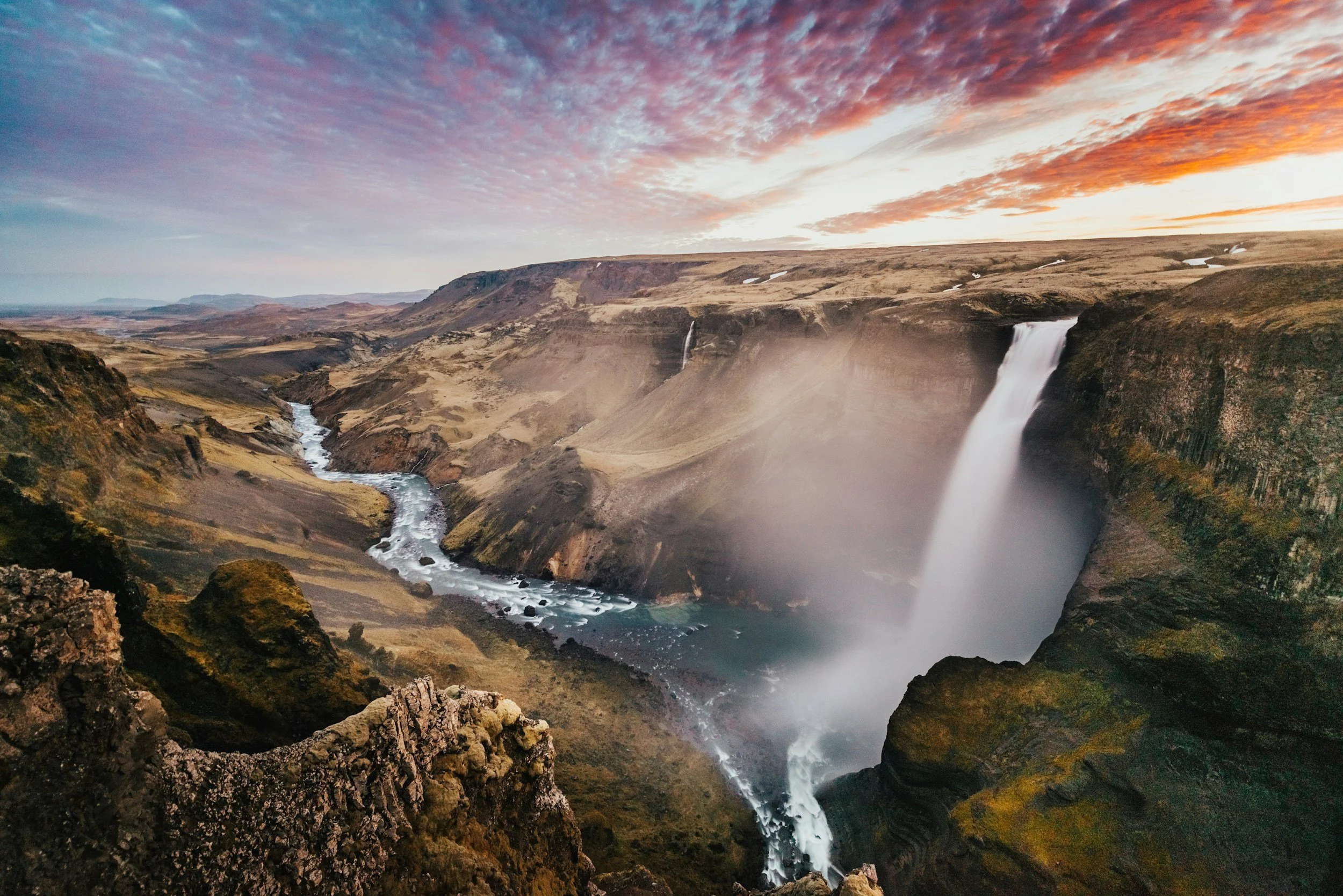 Háifoss waterfall dropping into a deep canyon beneath a colorful evening sky in Iceland