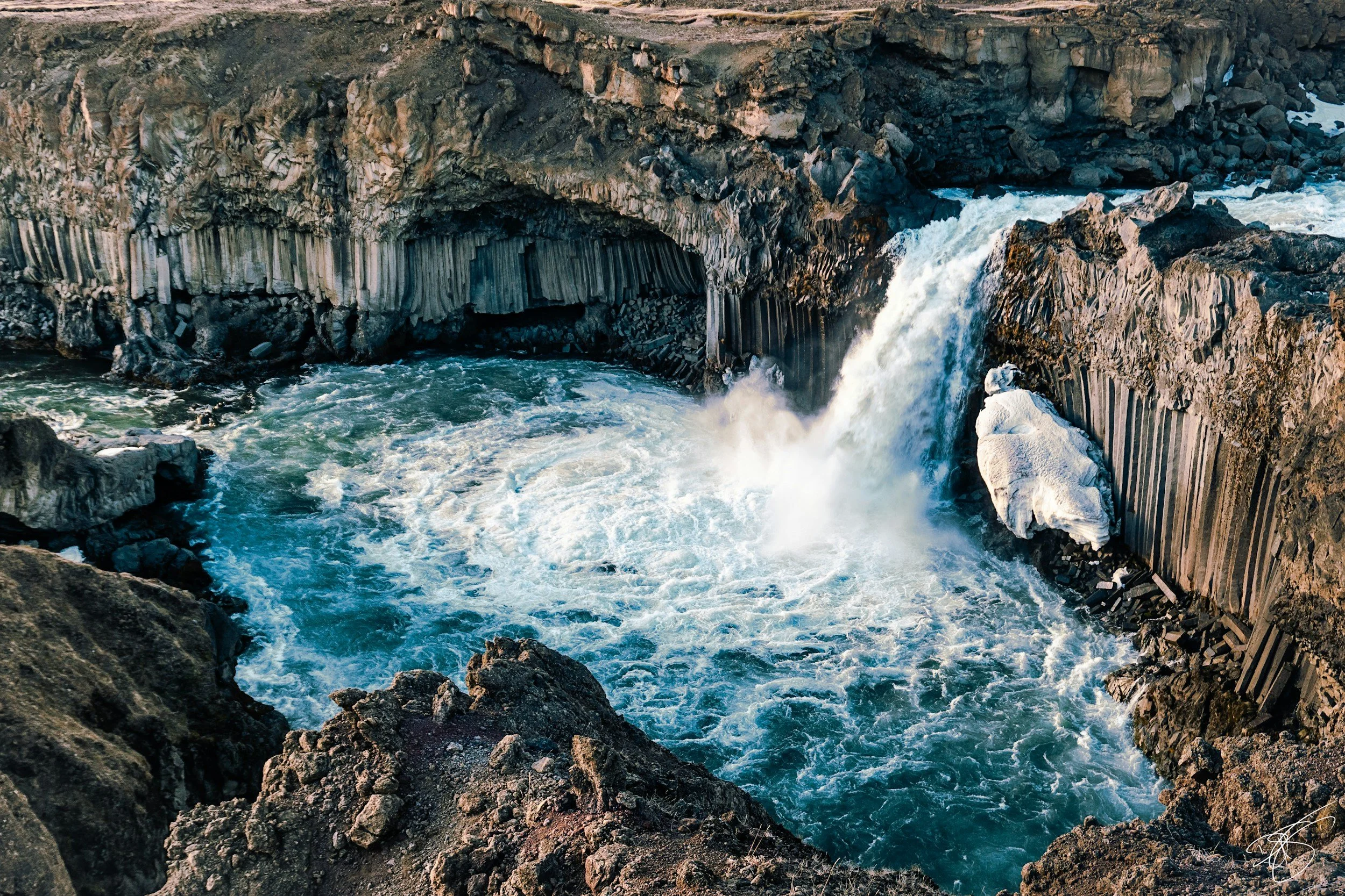Aldeyjarfoss waterfall surrounded by dark basalt columns and blue water in Iceland