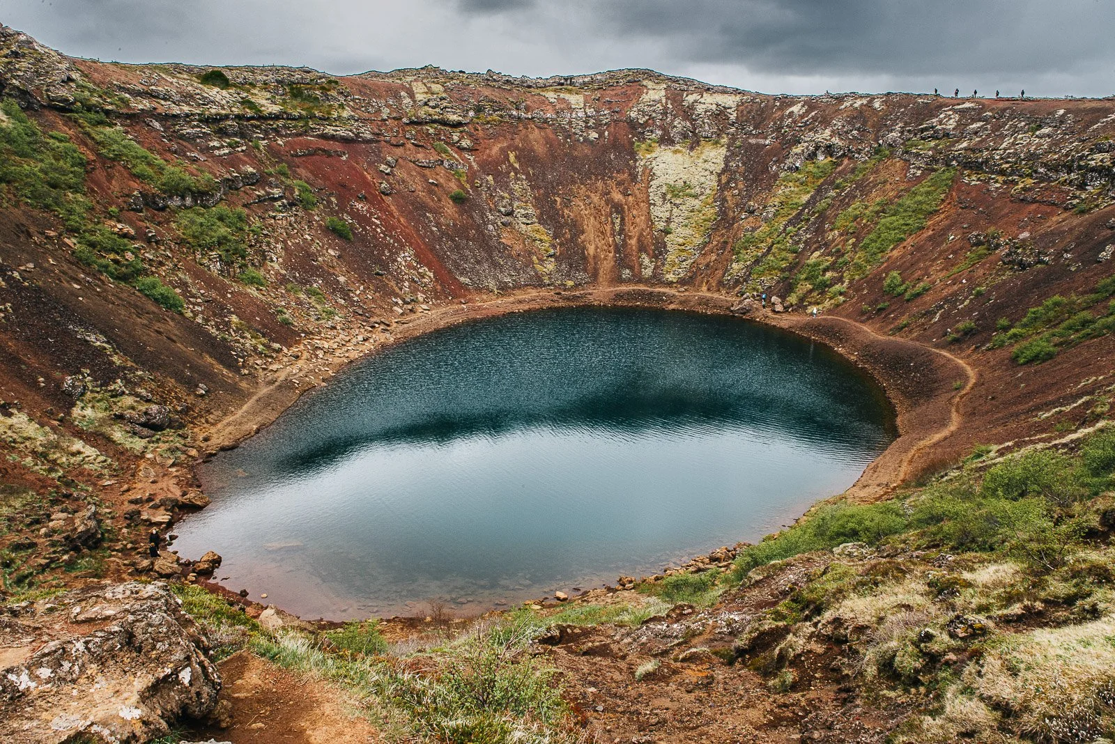 Blue-green lake inside the colorful Kerið volcanic crater in Iceland