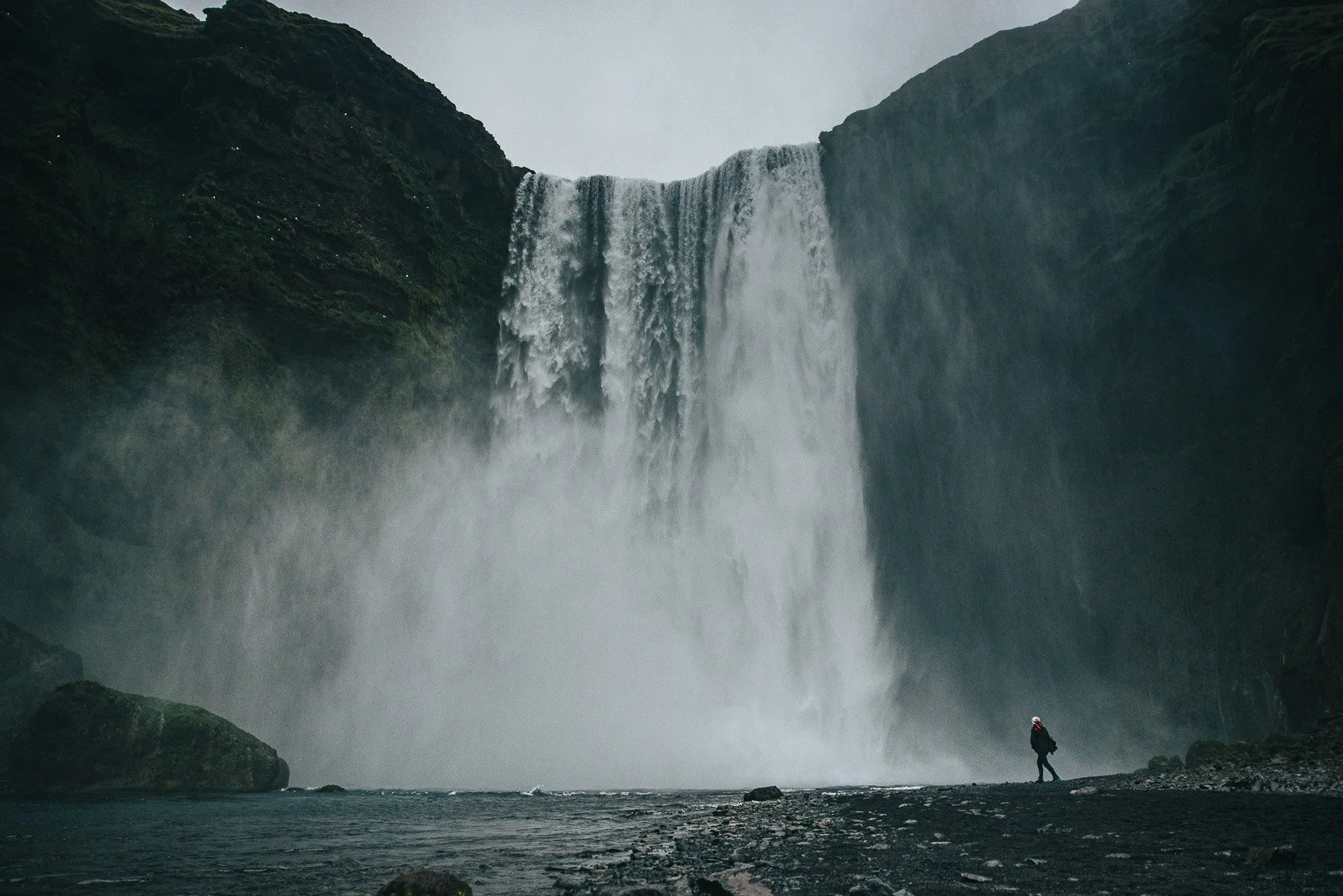Skógafoss waterfall on Iceland's South Coast with a person standing near the base
