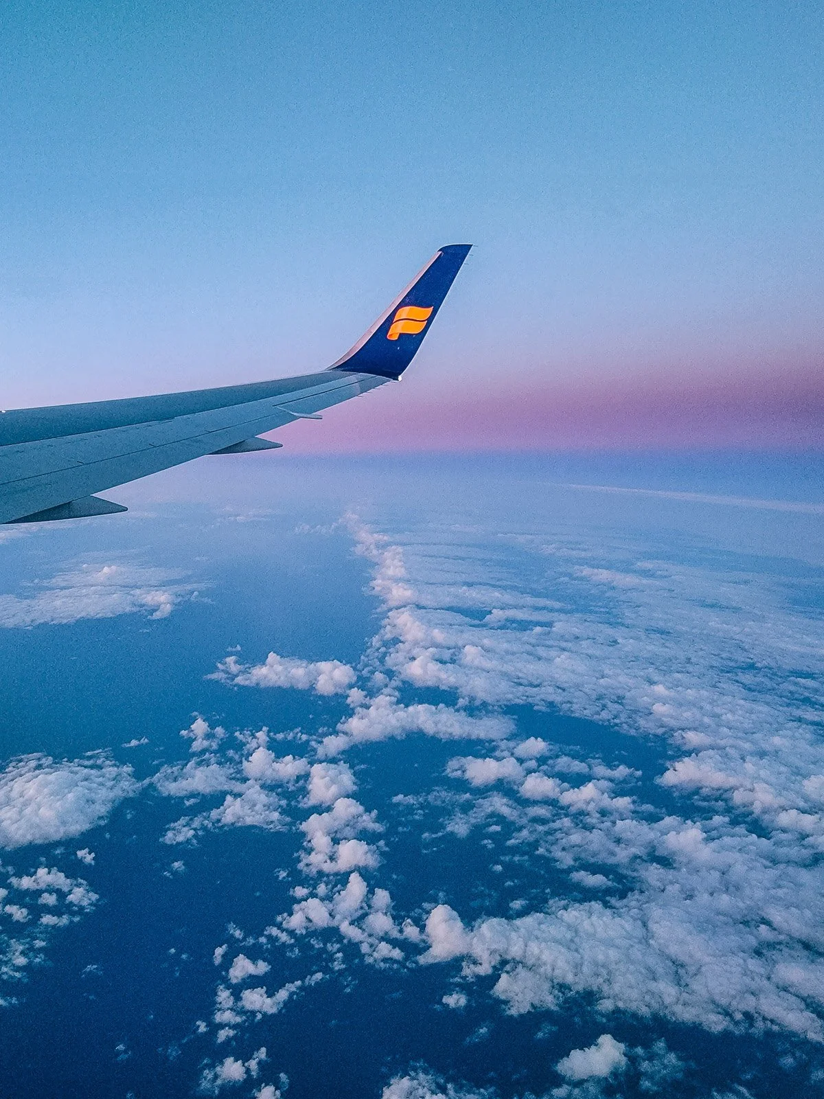 Icelandair airplane wing above the clouds at sunset