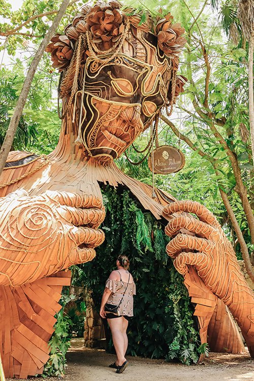 karen posed under ven a la luz sculpture in tulum mexico