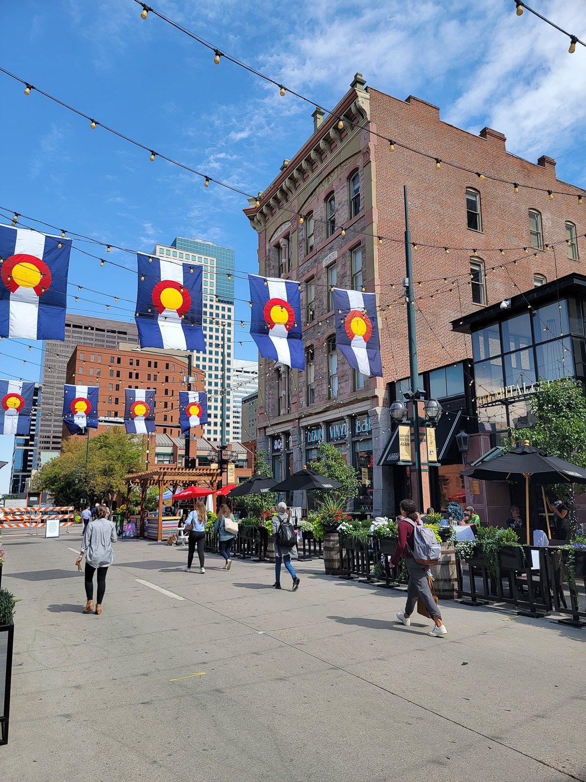 Larimer Square in downtown Denver with Colorado flags, historic buildings and outdoor dining
