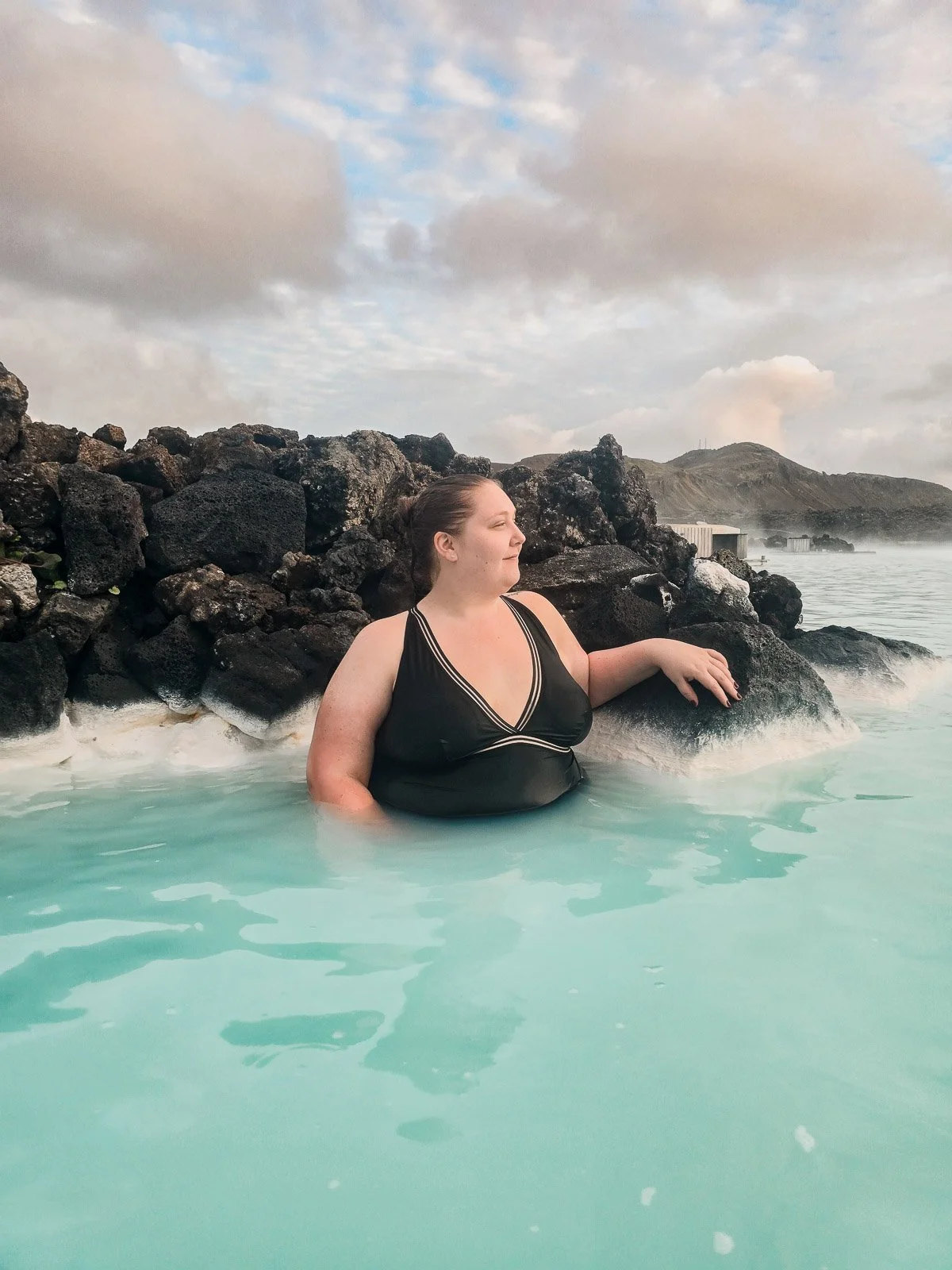 Traveler relaxing in the milky blue geothermal water at the Blue Lagoon in Iceland