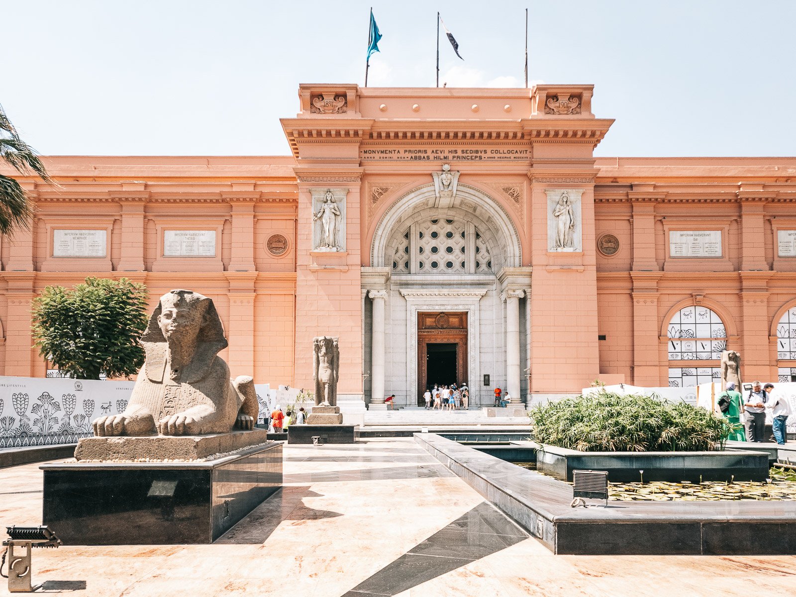 Egyptian Museum in Cairo with sphinx statues and visitors near the entrance.