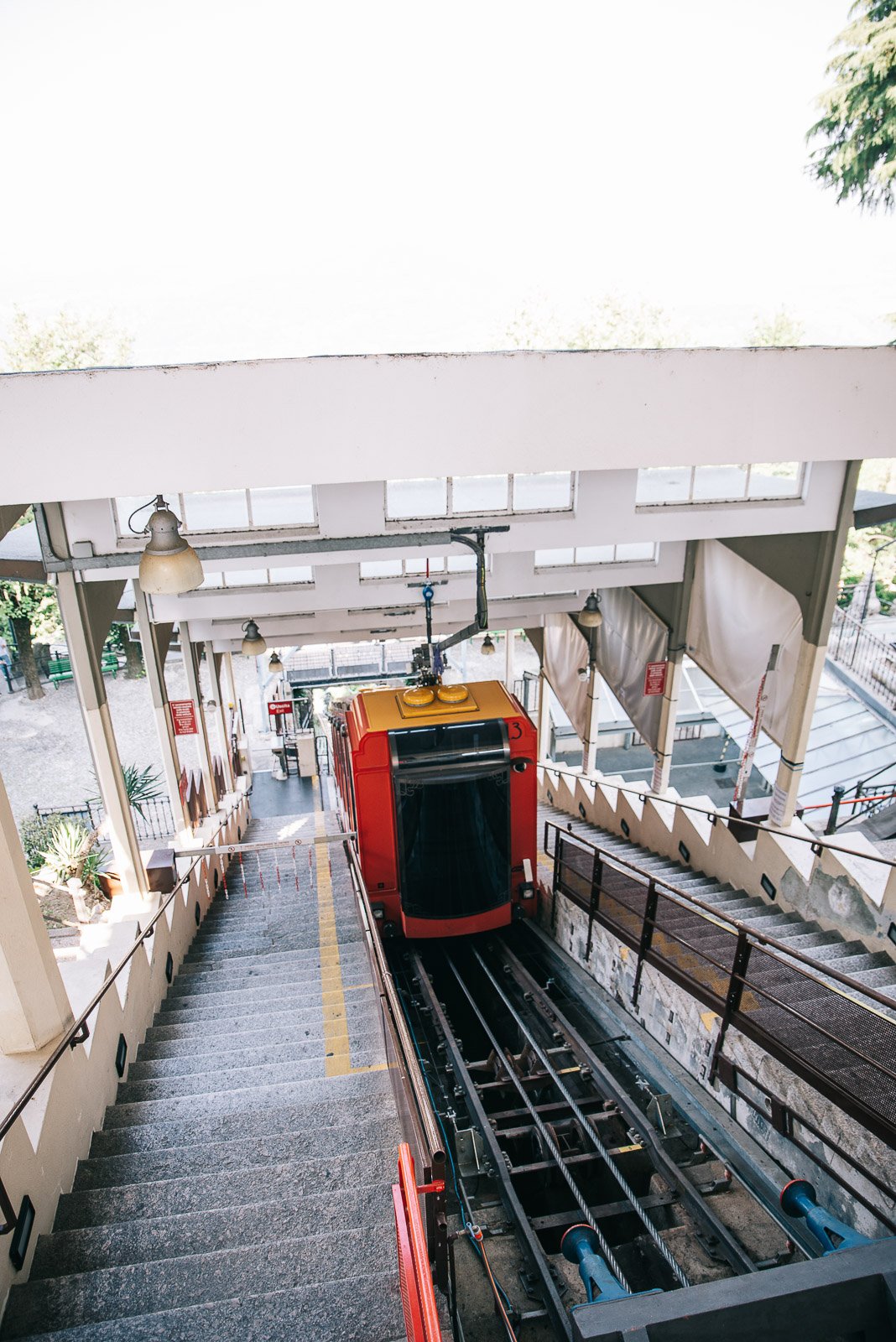 Red funicular car traveling along steep tracks in Italy