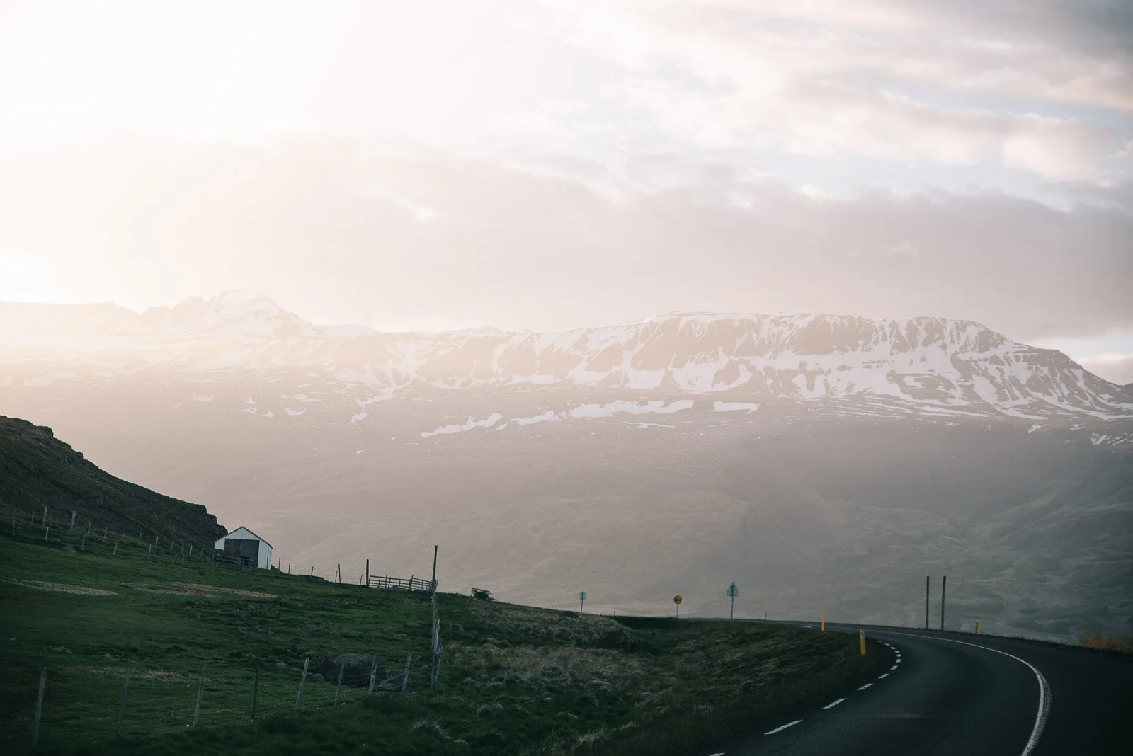 Winding road through Iceland with snow-covered mountains in the distance