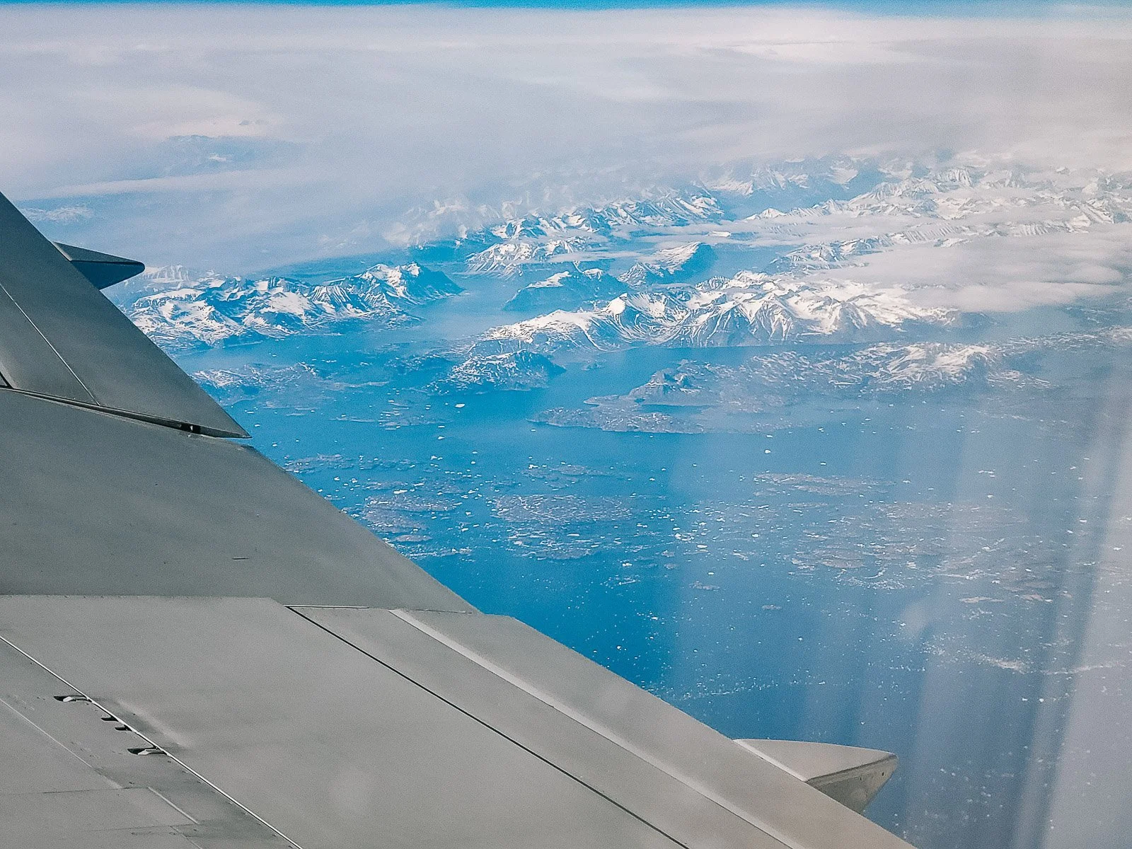 View from an airplane window over snow-covered mountains in Iceland