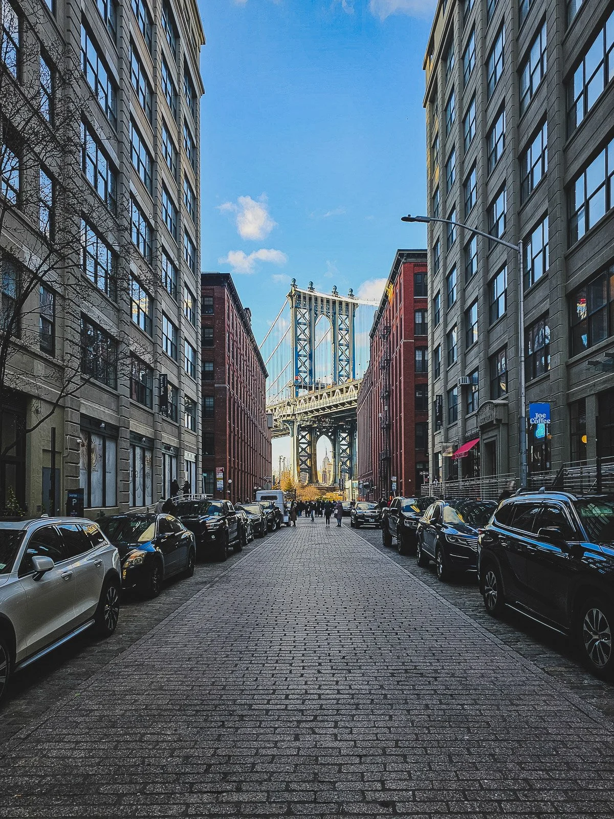 Manhattan Bridge framed by buildings along Washington Street in DUMBO, Brooklyn, New York City.