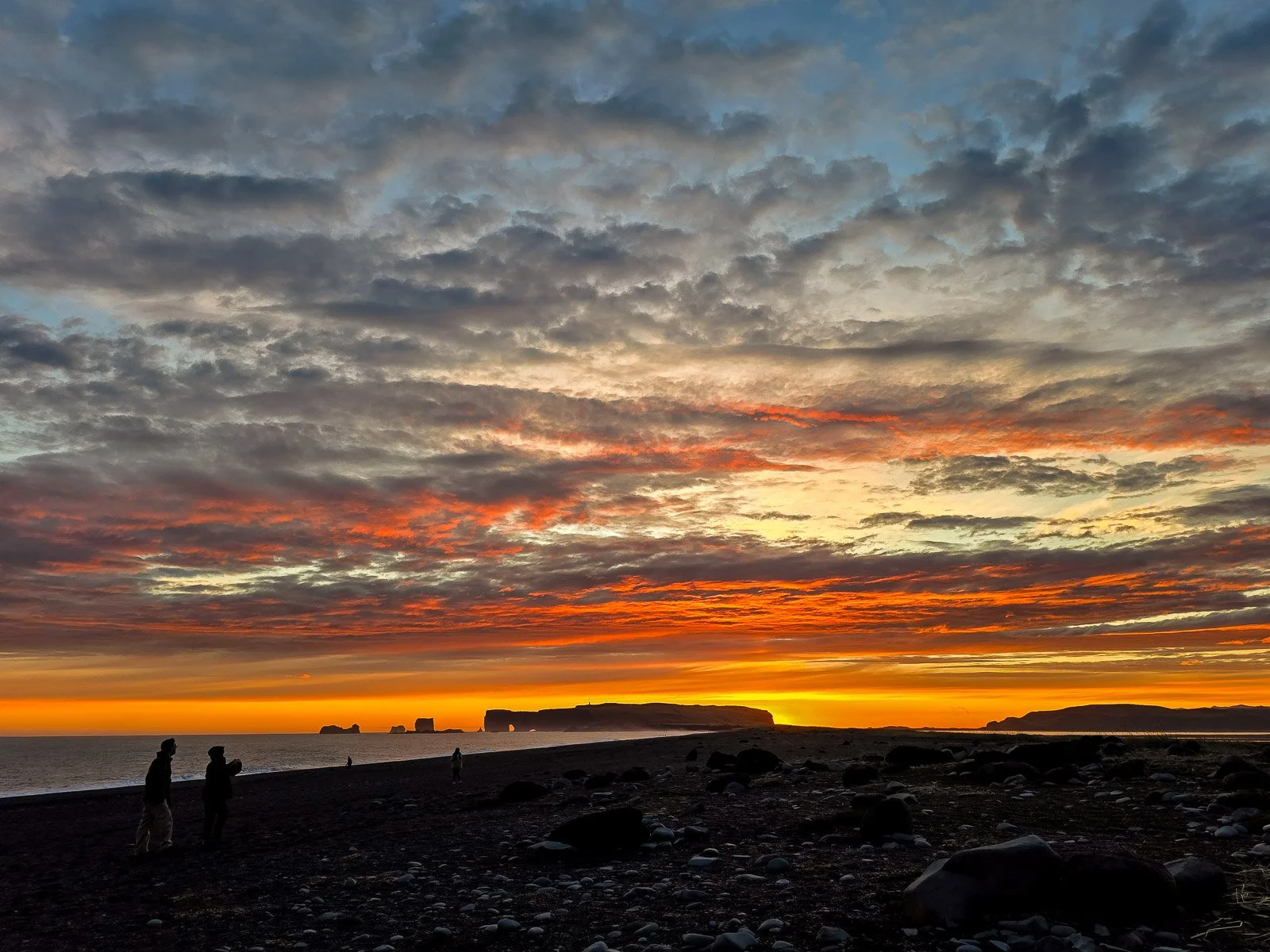 Colorful sunset over Reynisfjara black sand beach and sea stacks in Iceland