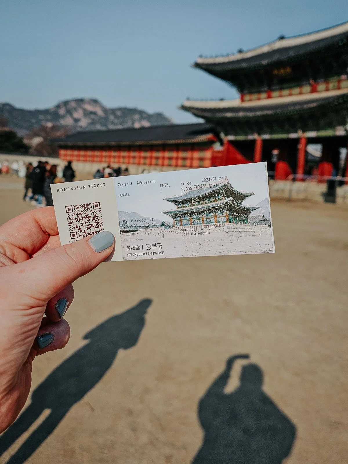 Admission ticket held in front of Gyeongbokgung Palace in Seoul, South Korea.