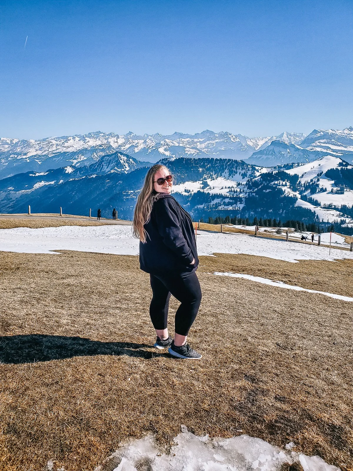 Traveler standing in front of snow-covered mountains in Switzerland