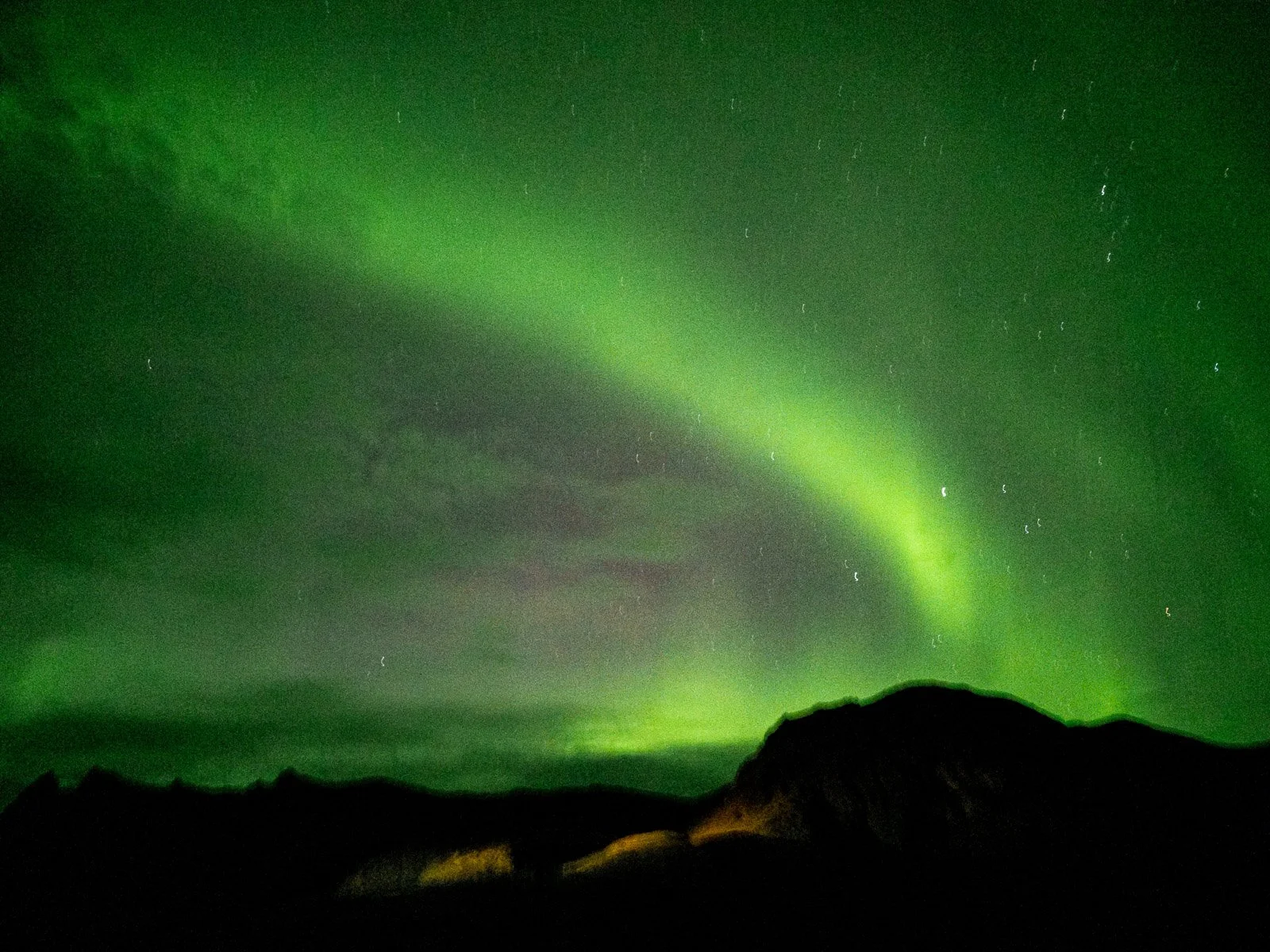 Green Northern Lights glowing across the night sky over Iceland