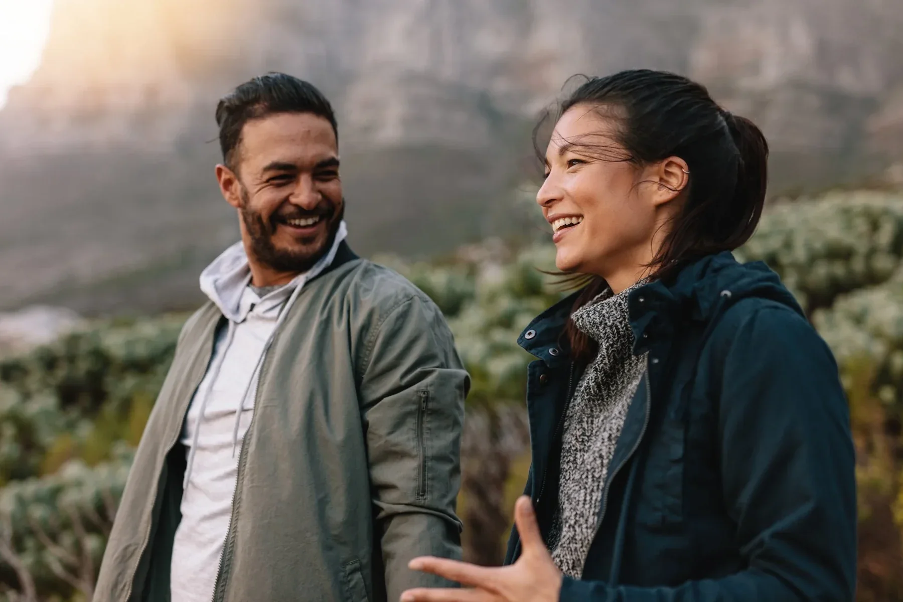 A couple laughing together while walking outdoors in nature