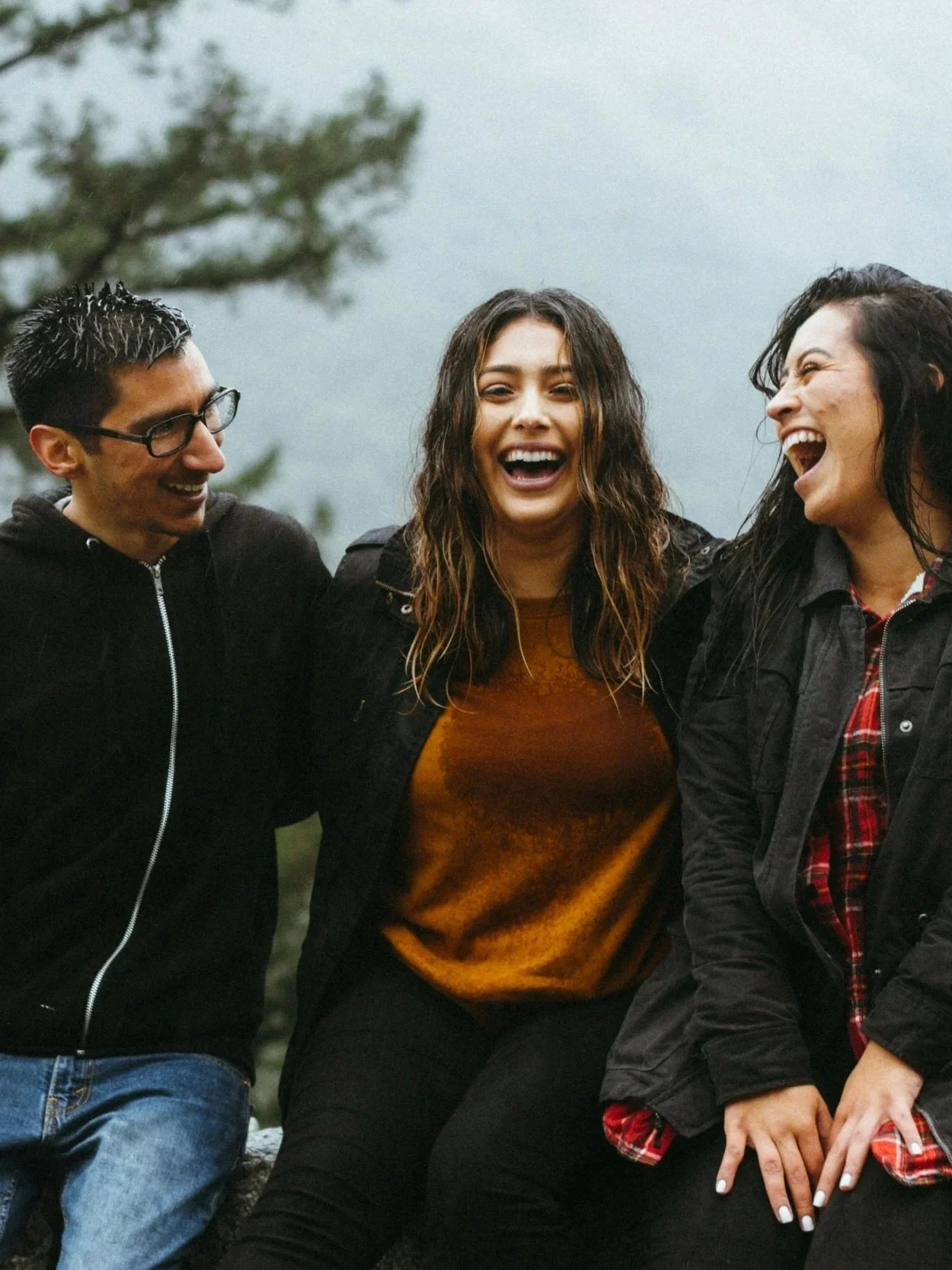 Three people sharing a moment of laughter outdoors