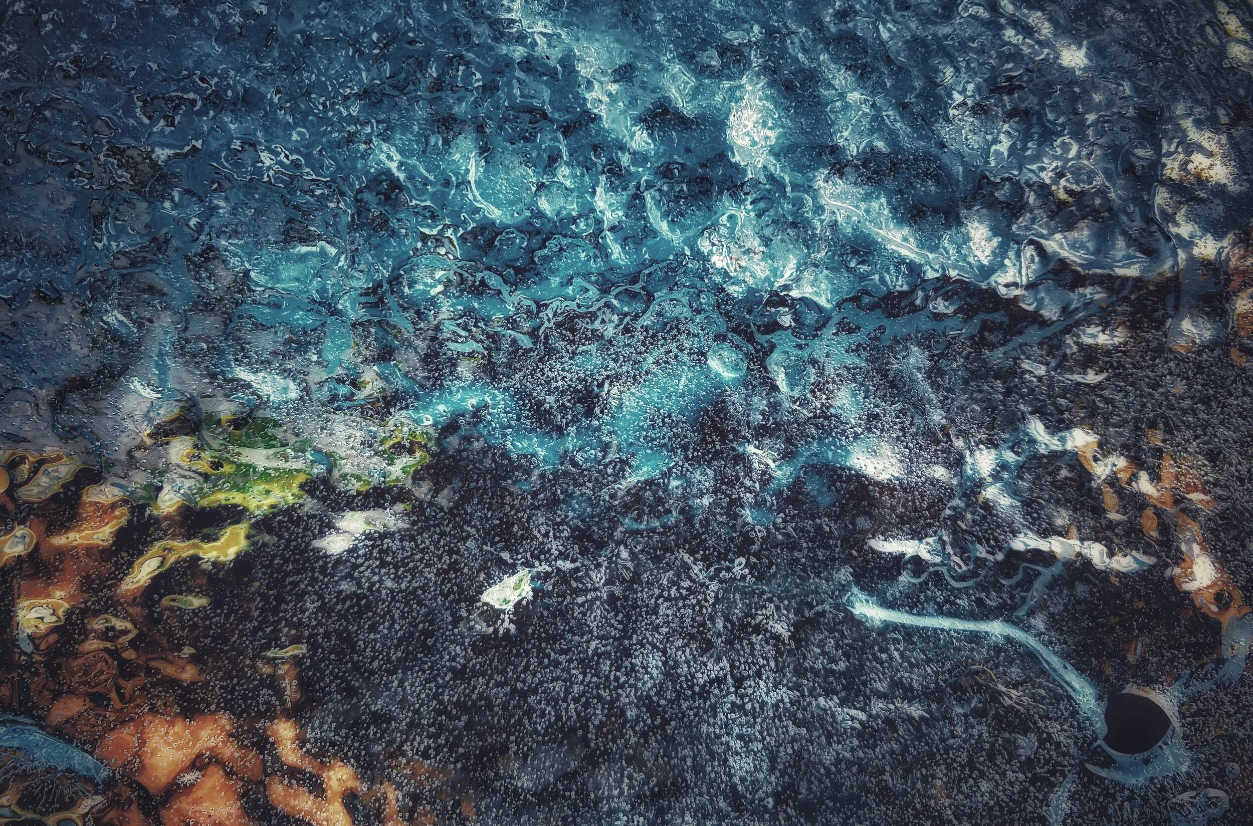 Ice on post with light from pond underneath.