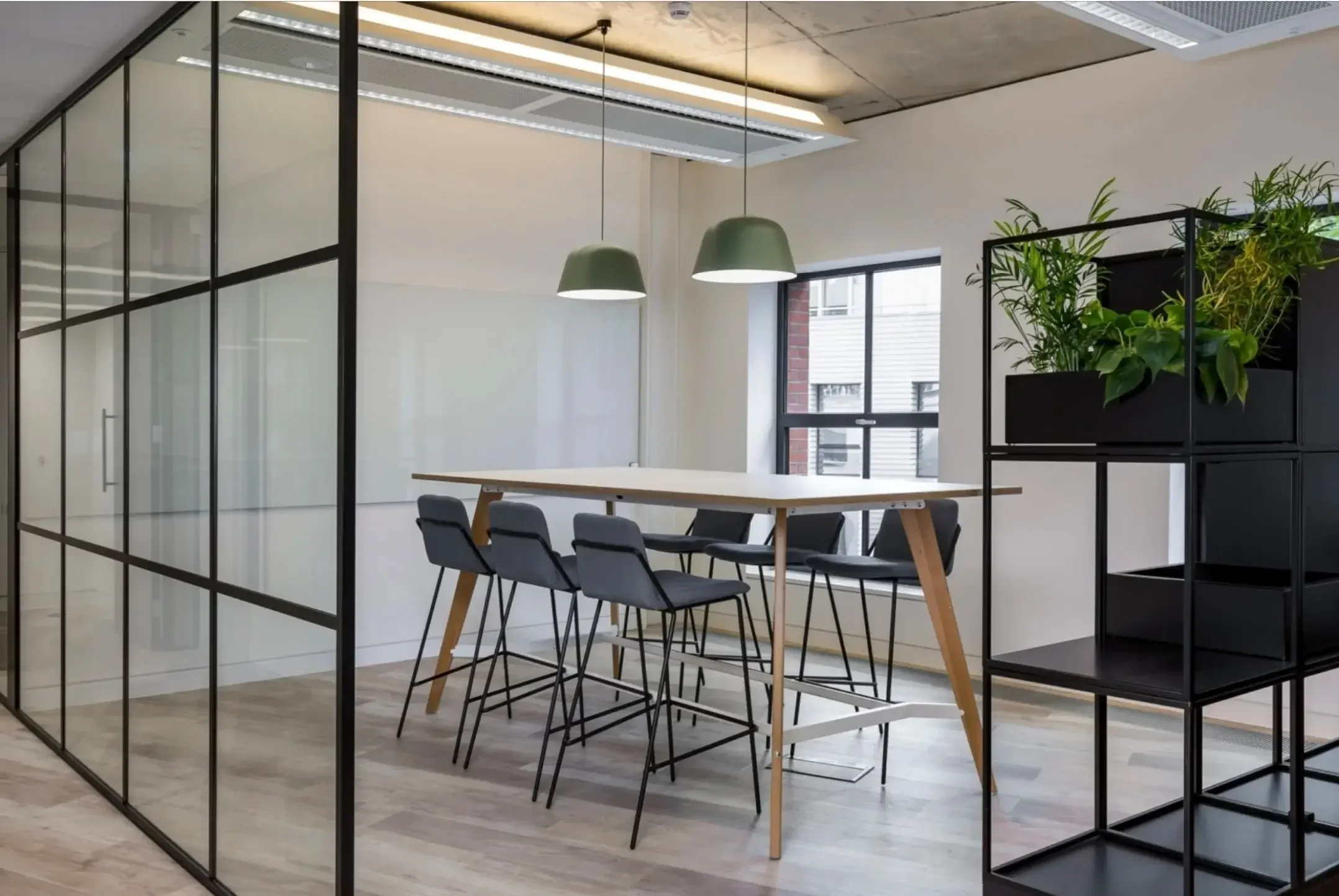 Modern office space with tall chairs and table.webp