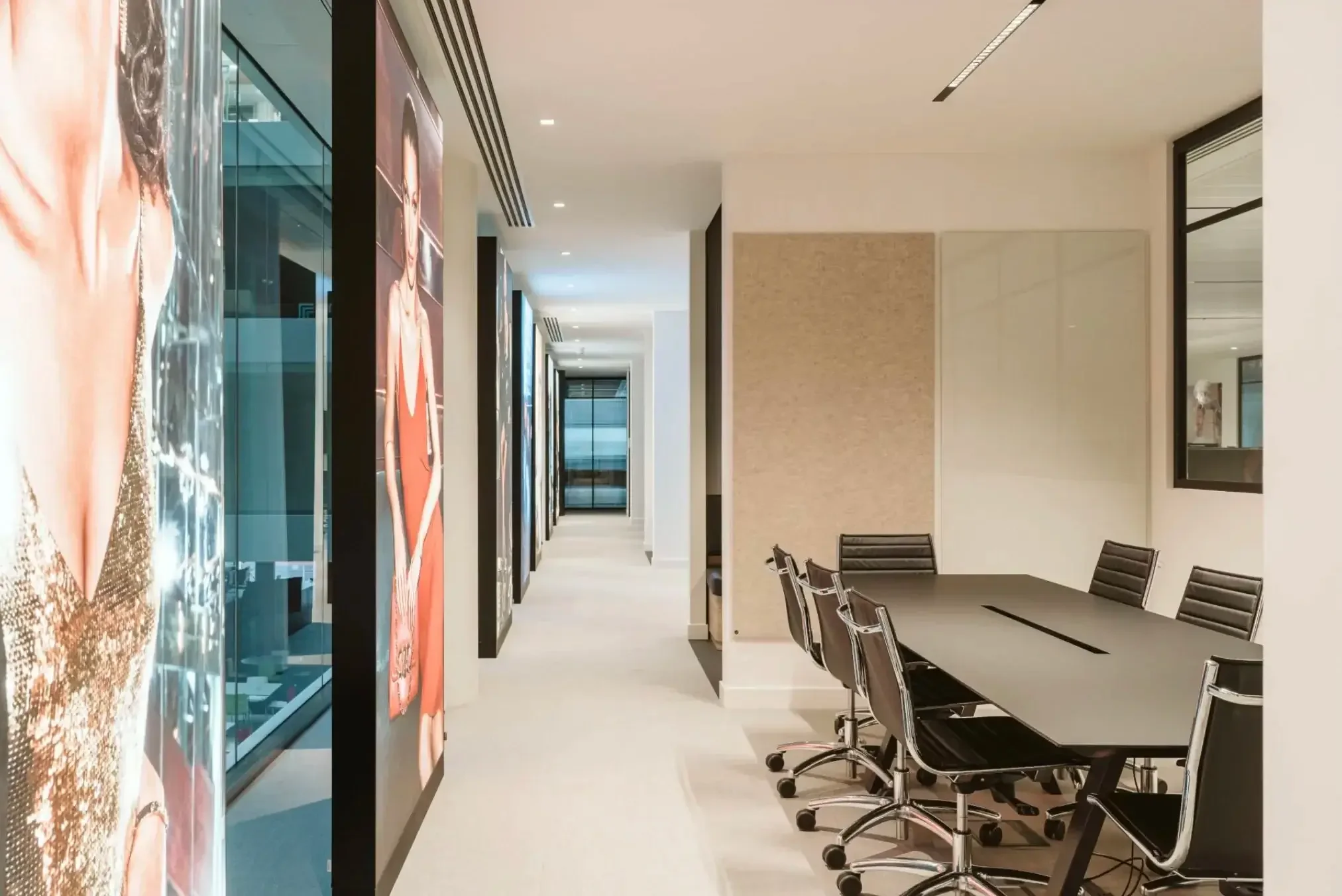 Office corridor with fashion images and glass whiteboard.webp