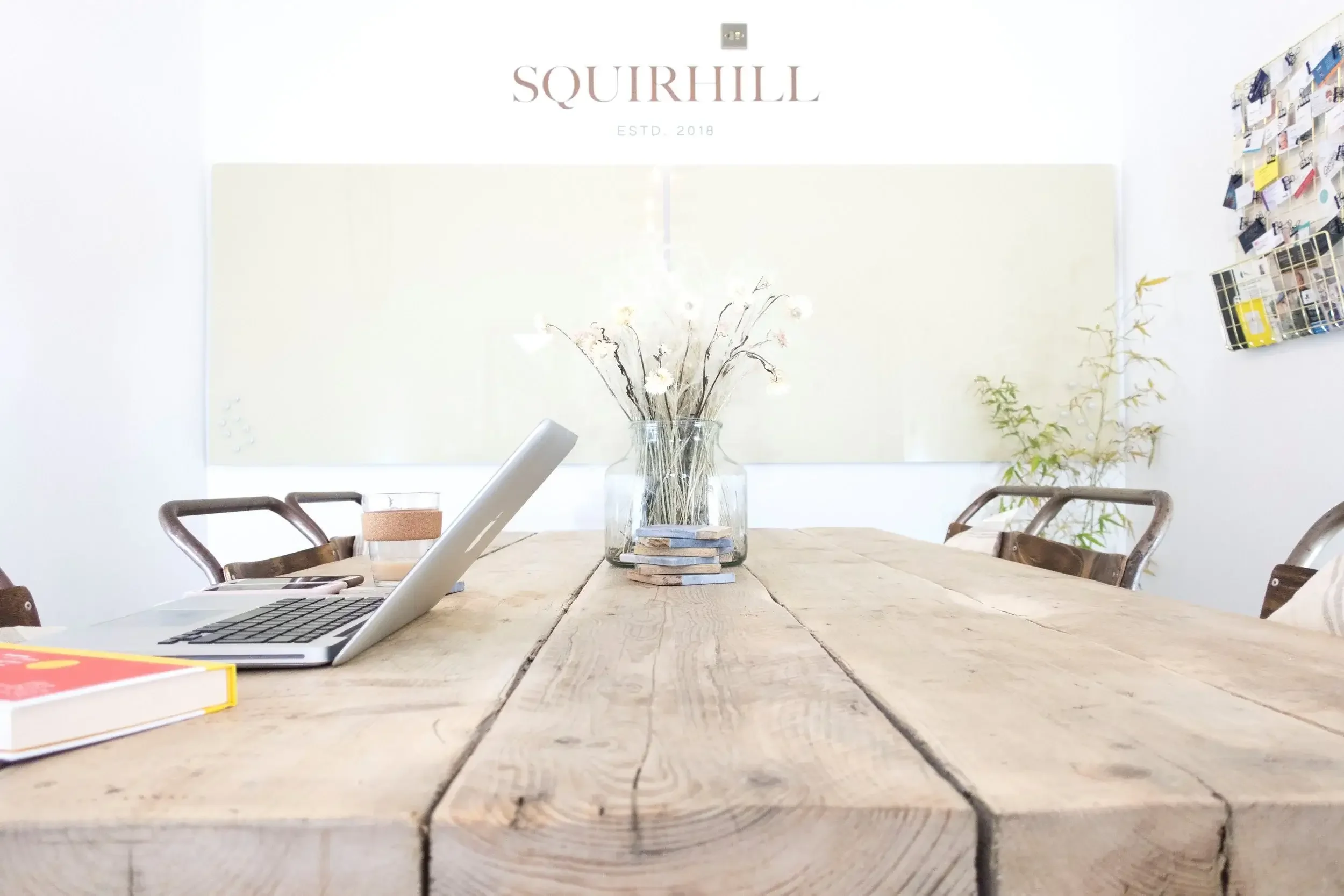 Wooden table with glass whiteboards and flowers.webp