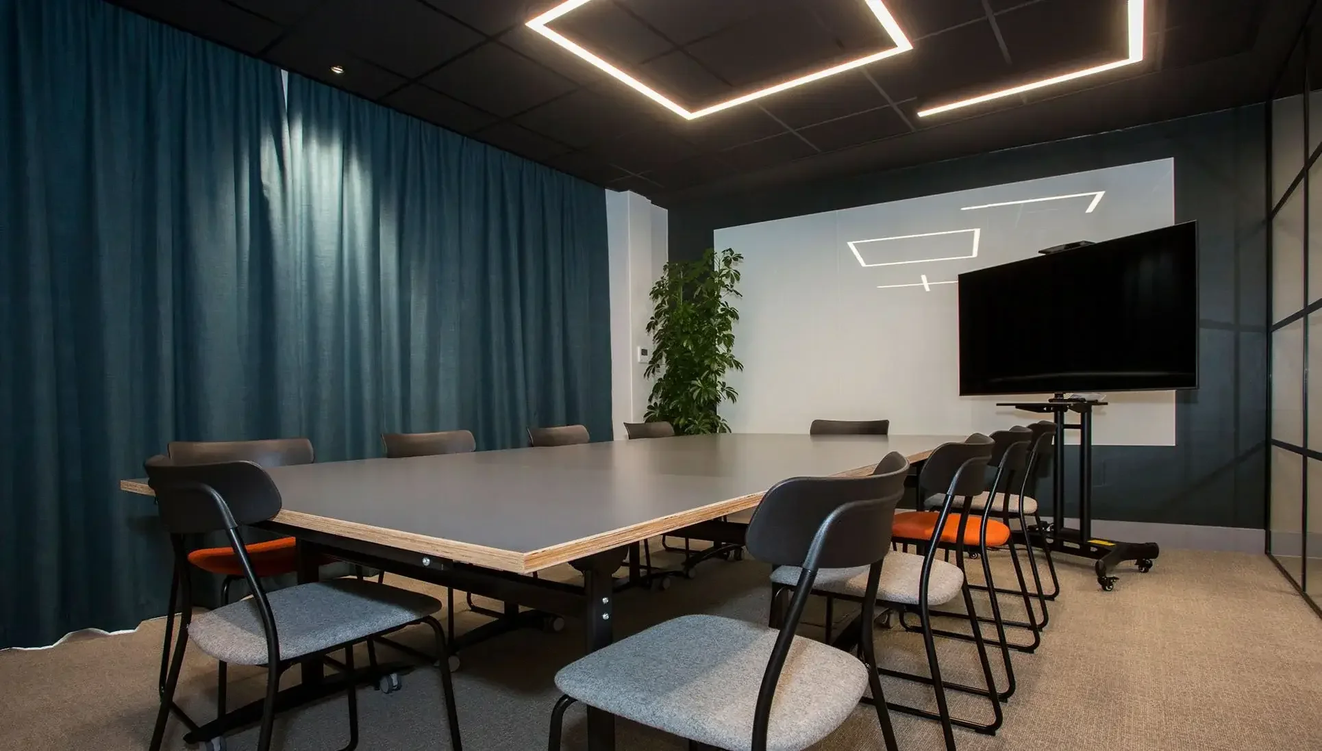 Dark meeting room with large white glass wipe board.webp