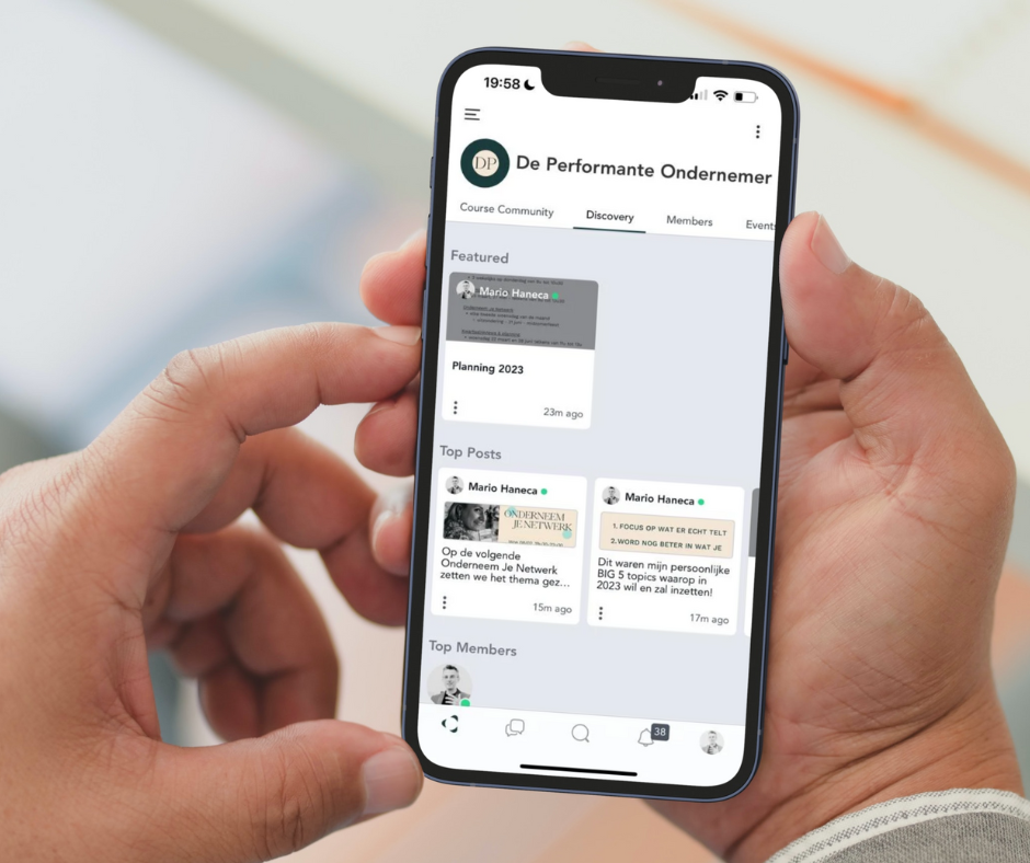 Een persoon houdt een smartphone vast die de website van 'De Performante Ondernemer' toont, met secties zoals 'Course Community', 'Discovery', en 'Members' zichtbaar.