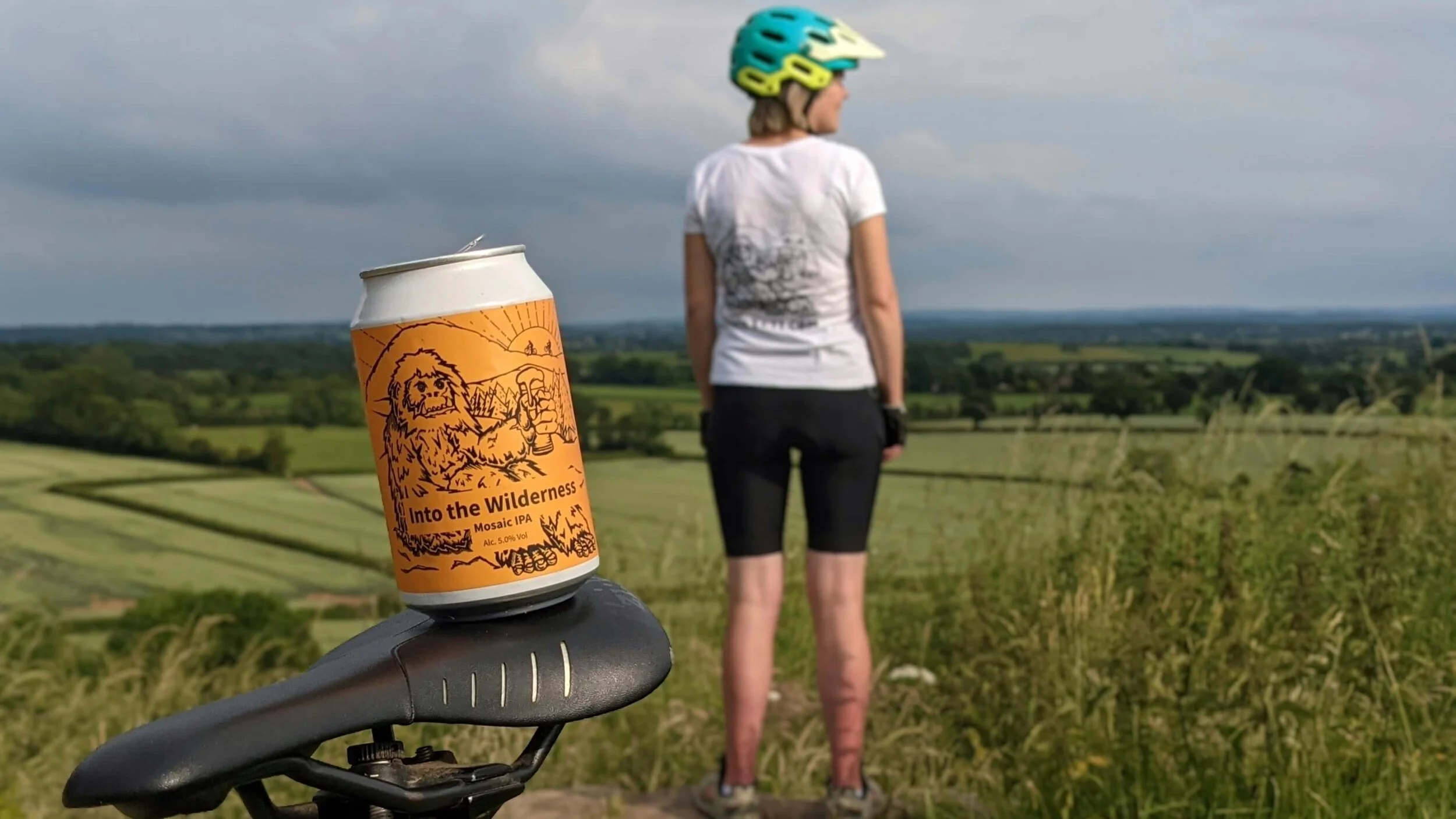 A picture of the BeerYeti beer with a cyclist looking out to a field on a gravel rude