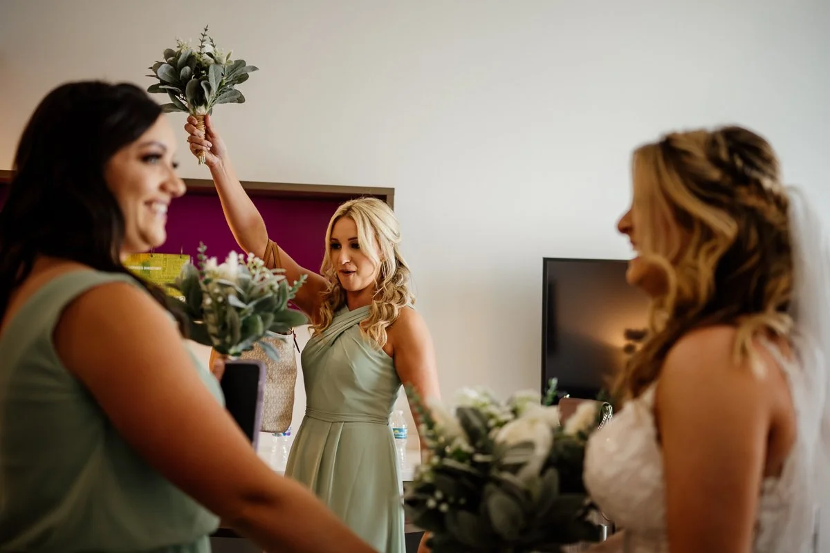 bridesmaids celebrate with bride as she gets ready for wedding