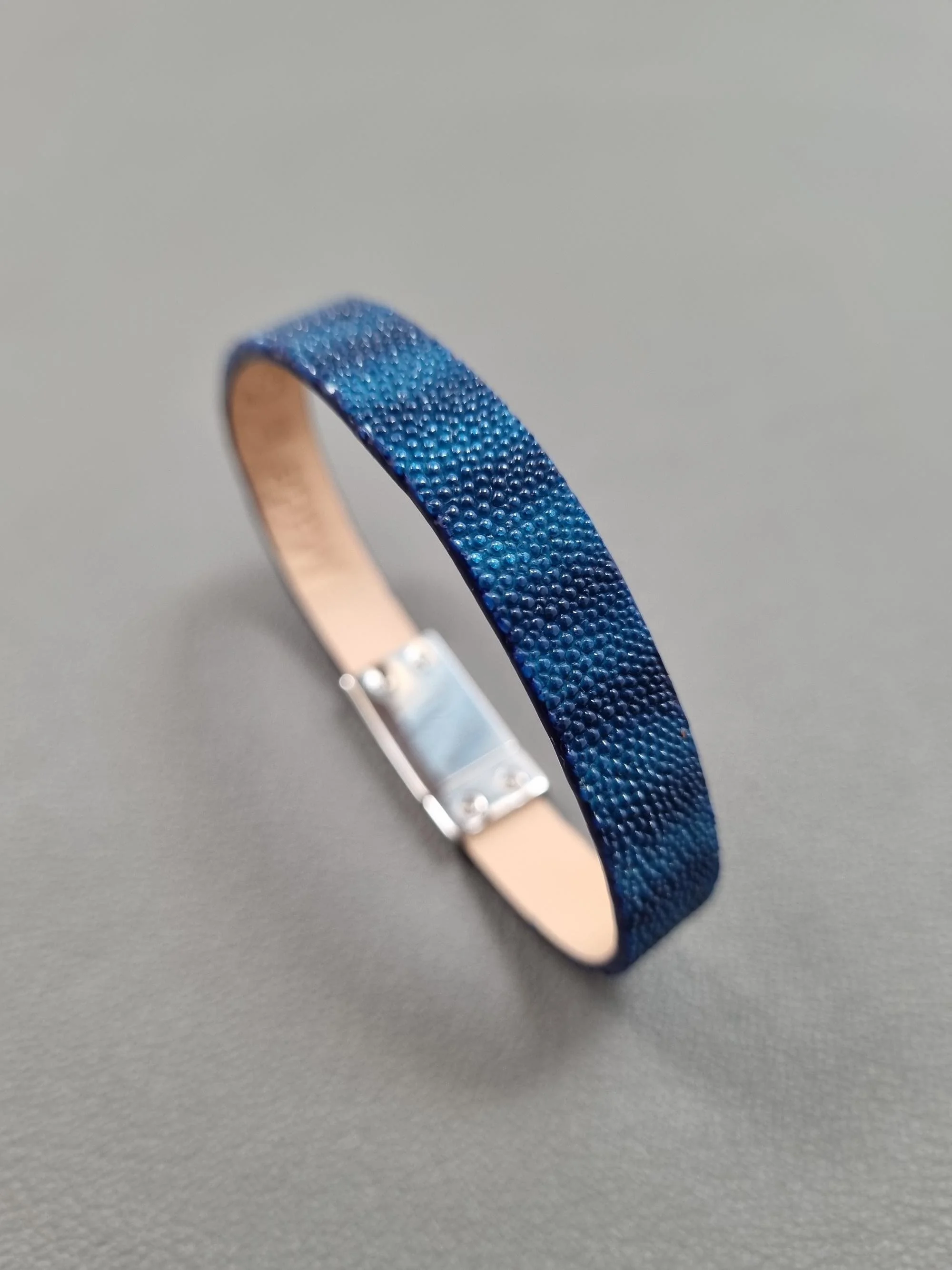 Angled view of a luxury blue stingray bracelet with a magnetic clasp, made by Pila Luxuria in Canada.