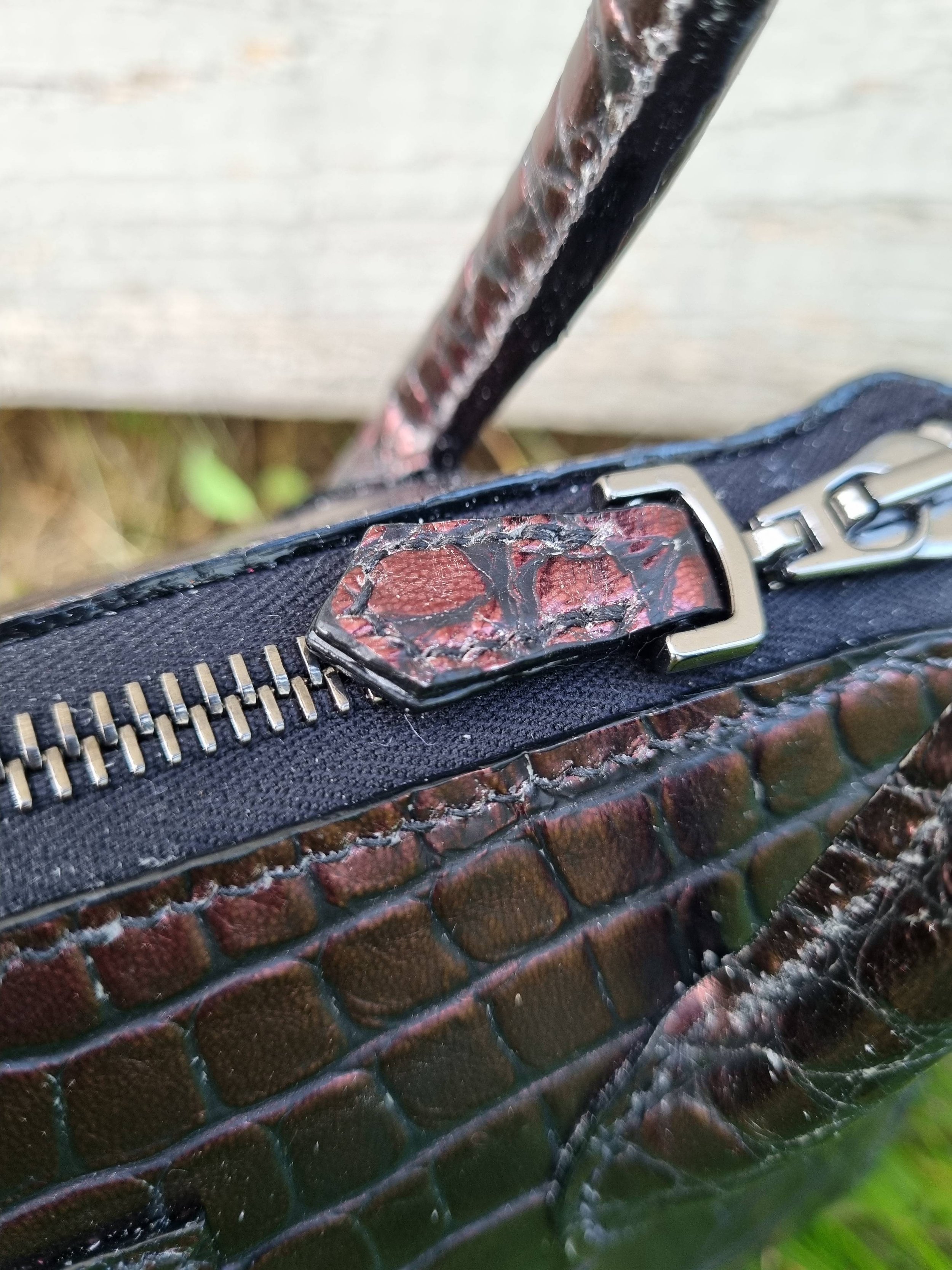 Zipper of a luxury dark cherry alligator leather leather handbag, made by Pila Luxuria in Canada.