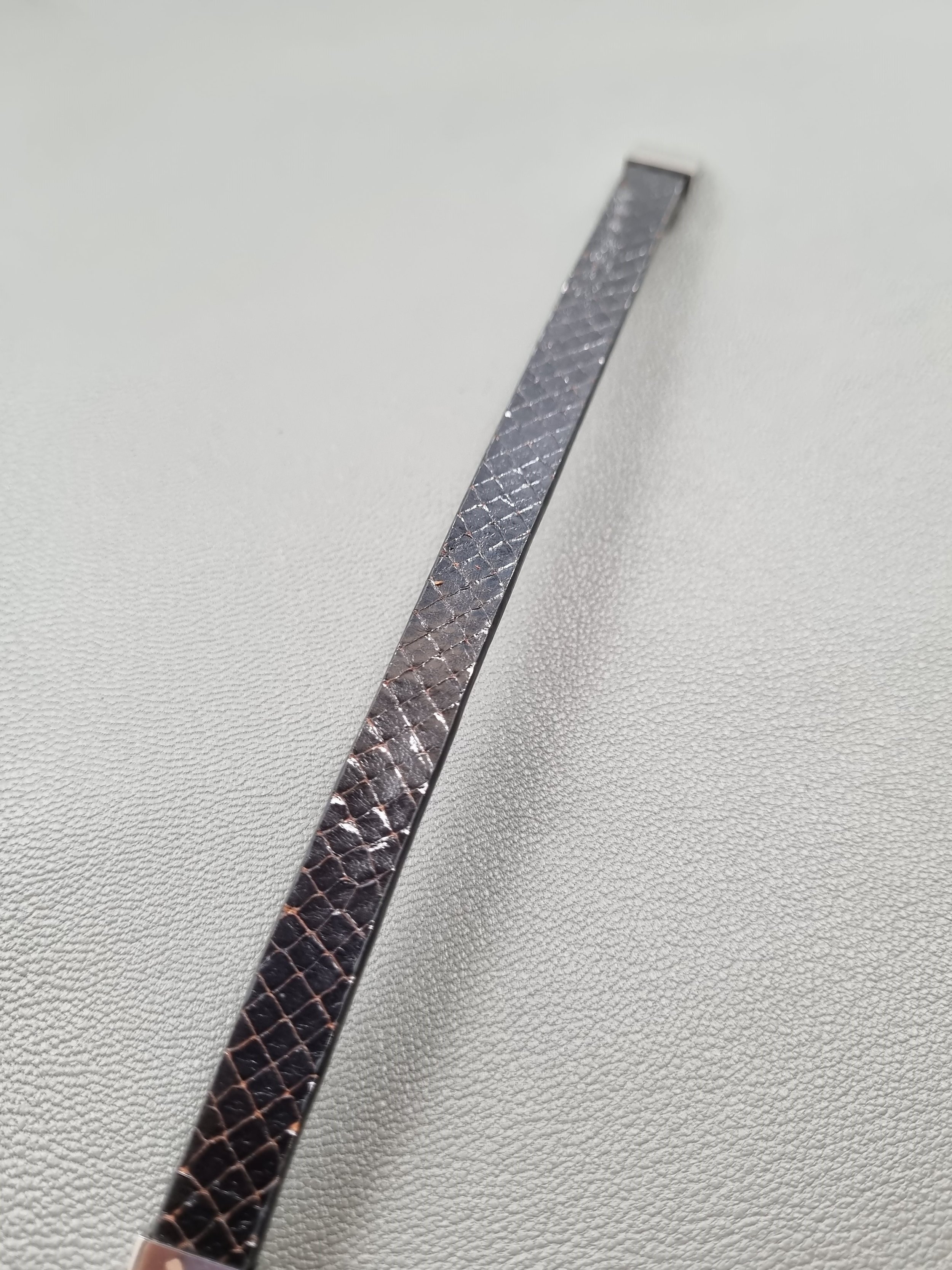 Black python leather bracelet laid flat.