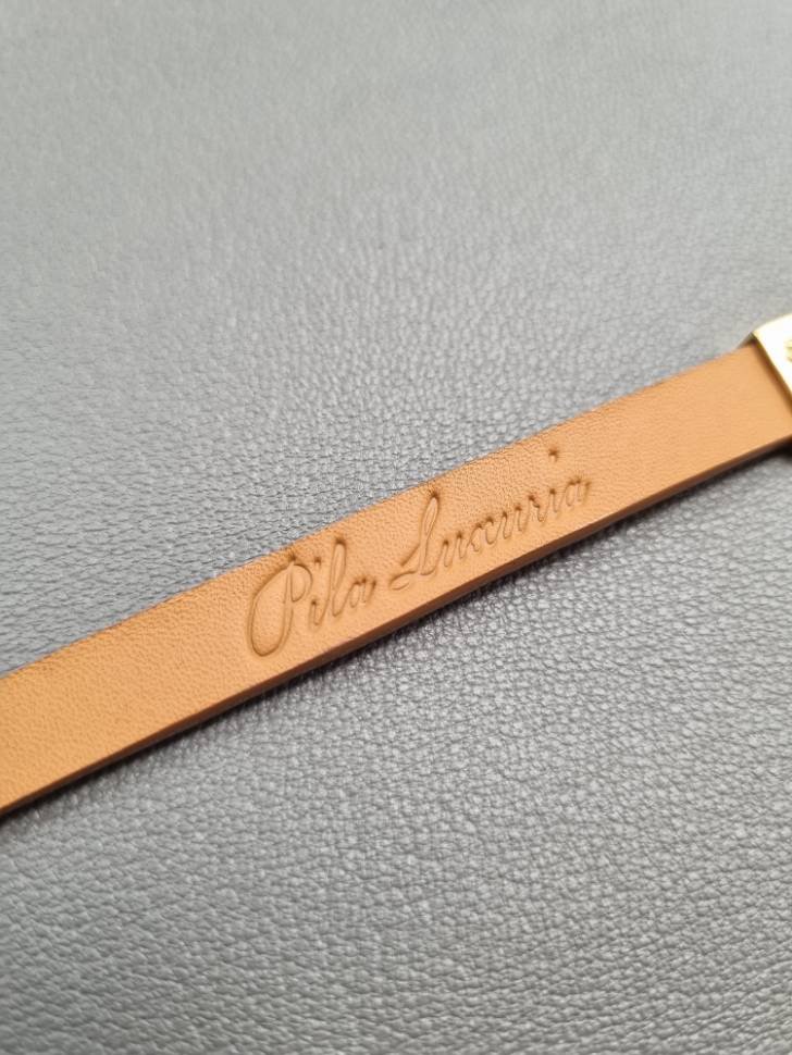 Logo view of a luxury cognac crocodile bracelet with a magnetic clasp, made by Pila Luxuria in Canada.