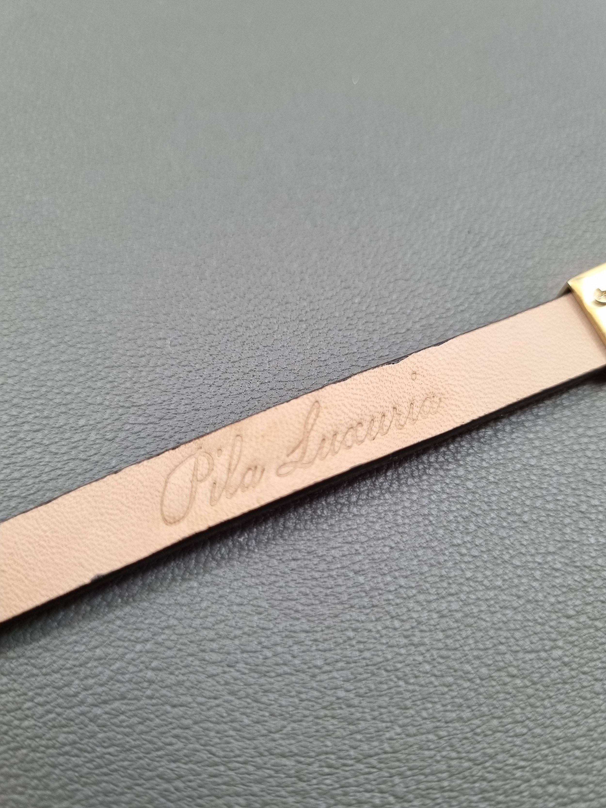 Embossed logo of a luxury brown calfskin leather bracelet with a magnetic clasp, made by Pila Luxuria in Canada.