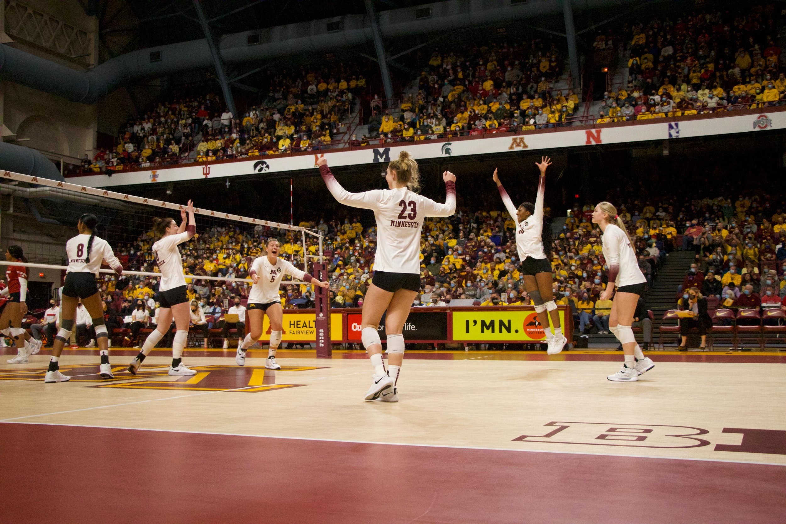 Minnesota Gophers opposite hitter Stephanie Samedy (10), setter Melani Shaffmaster (5), left, middle blocker Katie Myers (23) and other teammates celebrate after scoring a point in the first set against Wisconsin at Maturi Pavilion in Minneapolis, Mi