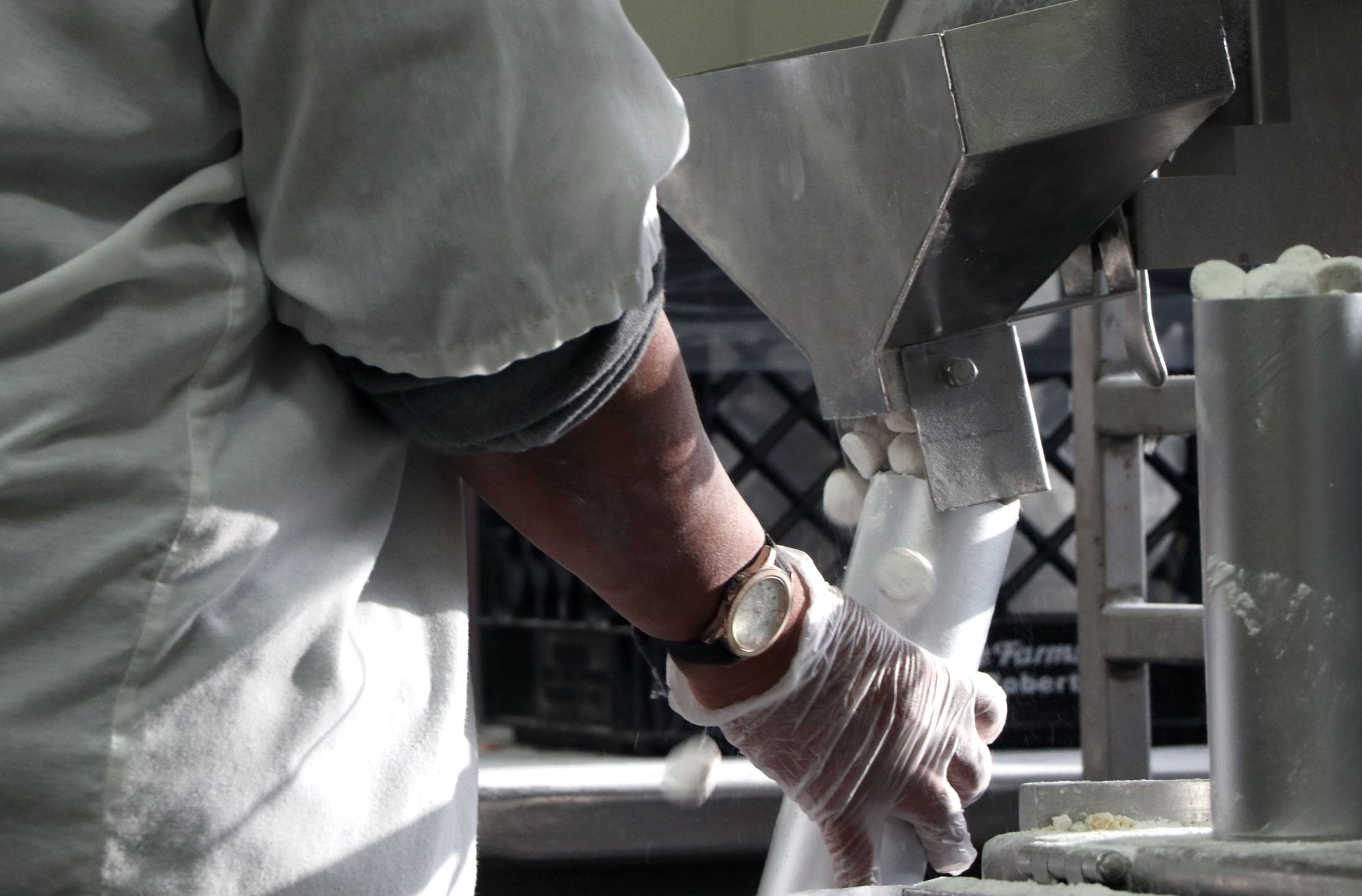 Birddee Jefferson operates the machine that funnels cookies into cylinders at Grandma’s Bakery in White Bear Lake, Minn., on Thursday, Dec. 9, 2021. Jefferson works at the bakery from 9 a.m. to 4 p.m. most days, working at the cookie packaging statio