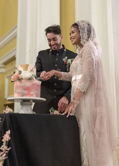 A bride and groom cutting their wedding cake at a reception.