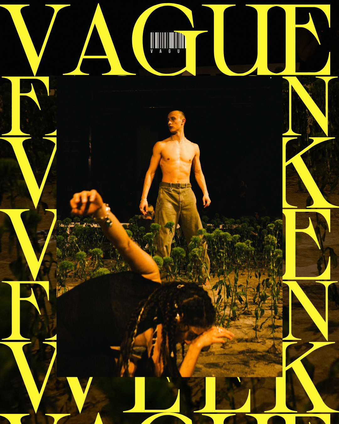 Portrait of a bald, shirtless male model in belted trousers standing in an artificial flower field in a dark studio across from a brunette female model lamenting on the ground. Both are wearing silver Octi bracelets, necklaces and rings.