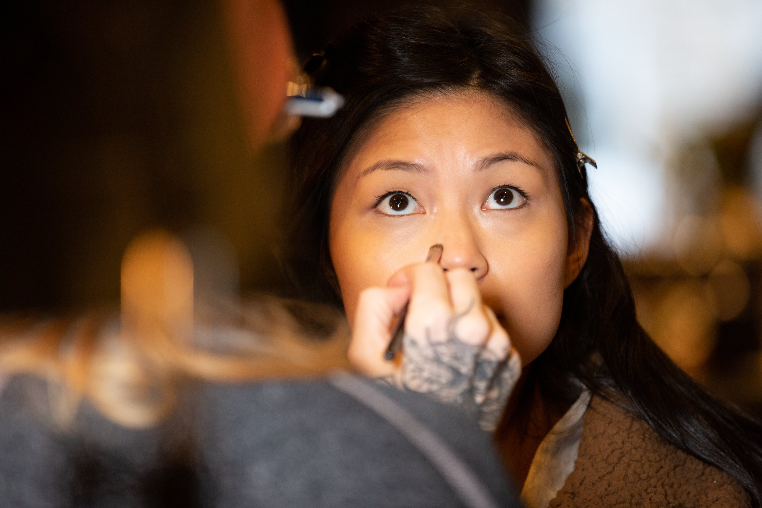 Woman having makeup applied, focused on eyes