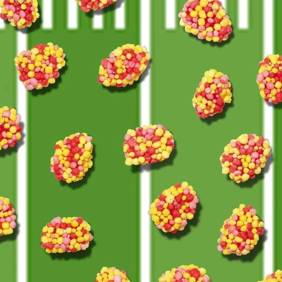 Huge Galdones photograph for Ferrara Candy Nerds Gummy Clusters with pastel pink, red, and yellow round pieces on a patterned green and white striped background.