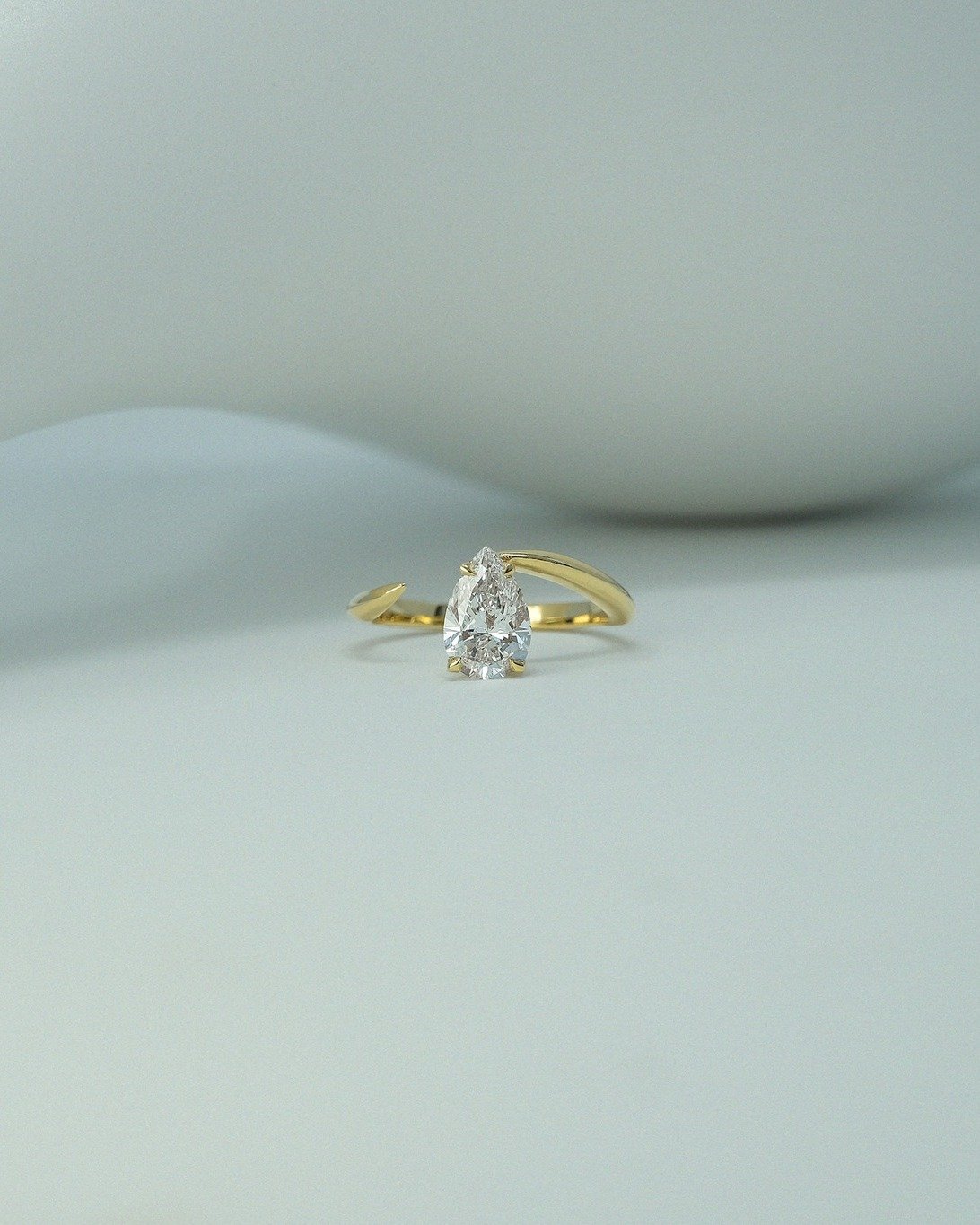 The customised Tear Drop Ring features an off-centre and open-ended design. It is tiger-claw-set with a 1ct white diamond in 18ct yellow gold with smooth edges modification.

Handmade in our London workshop, tested and hallmarked by the London Assay 