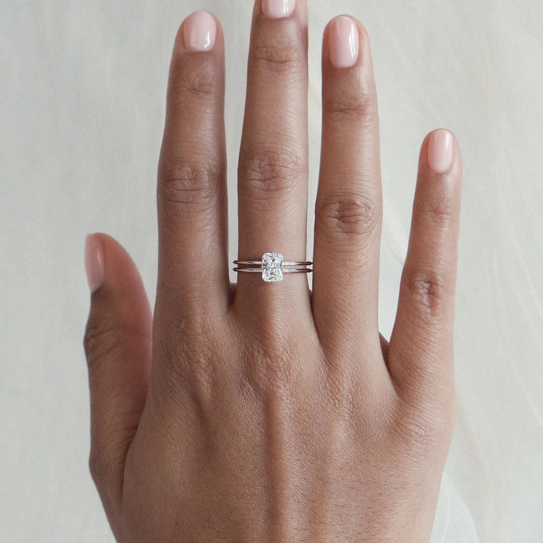 The Xari Ring features an exquisitely crafted geometric double-band design, echoing the majestic symmetry of Mayan architecture. At its centre, a natural white diamond is cradled in a cross-style setting reminiscent of a tiger's claw, symbolising bot
