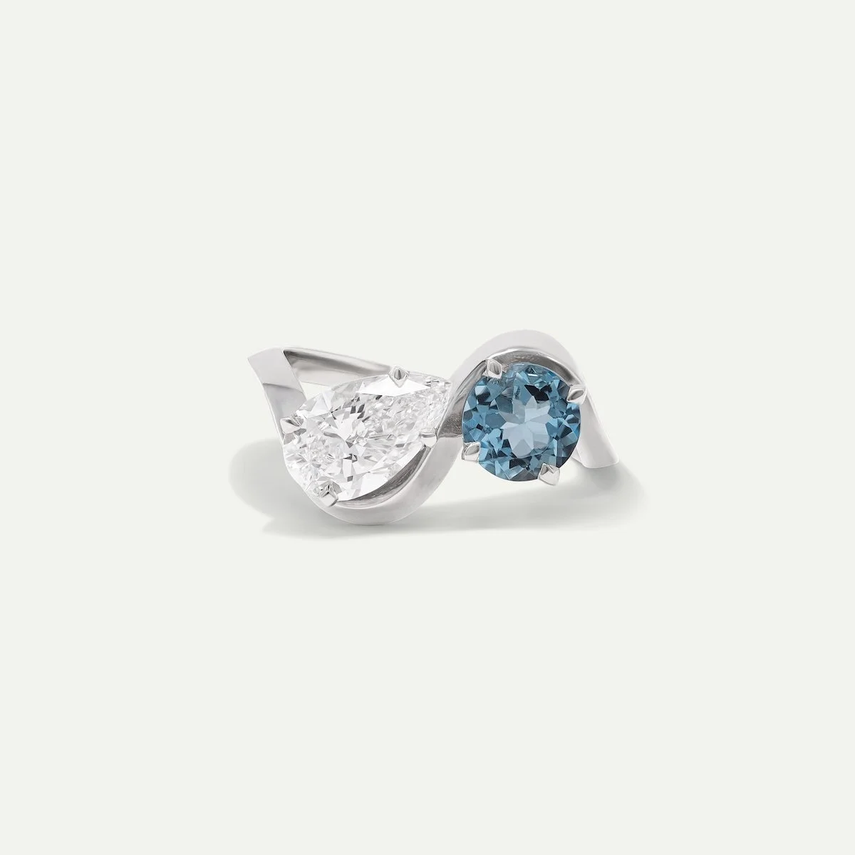 Bespoke modern engagement ring of wavy dune architectural platinum ring with pear-cut diamond and round aquamarine EDXU bespoke jewellery london