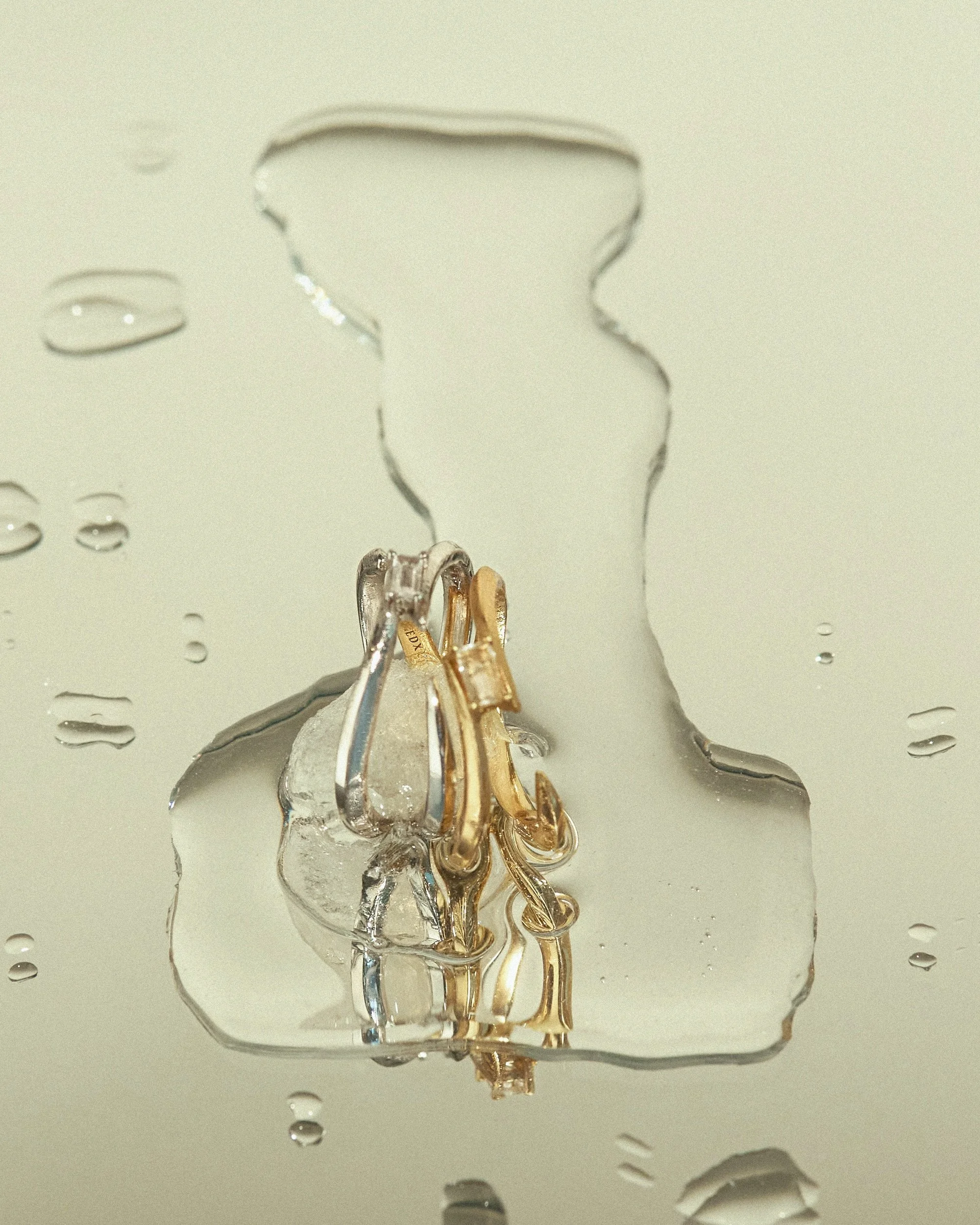 EDXU London campaign of Dew Ring in 18k gold vermeil and rhodium plated silver with emerald-cut white topaz on melting ice