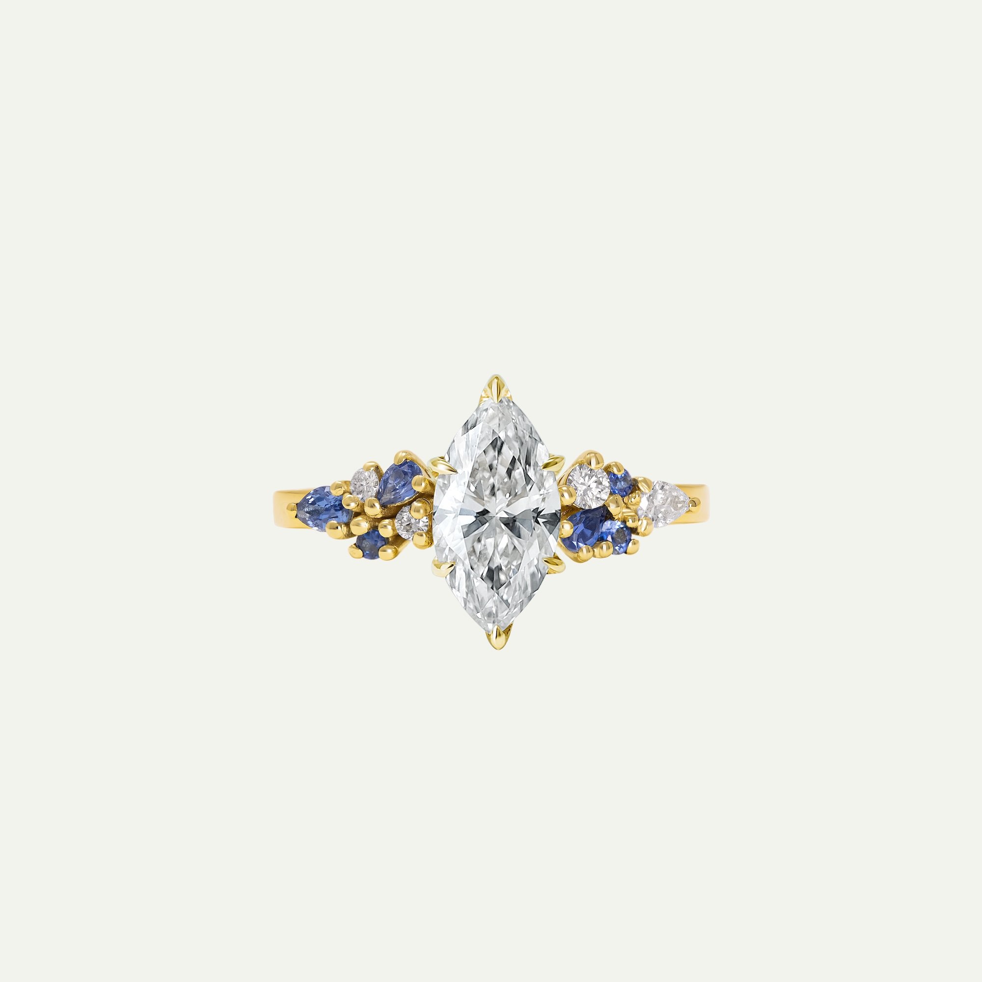 Celeste alternative engagement ring in 18ct yellow gold with marquise-cut white diamond and various shapes and sizes diamonds and sapphires from EDXU London bespoke jewellery