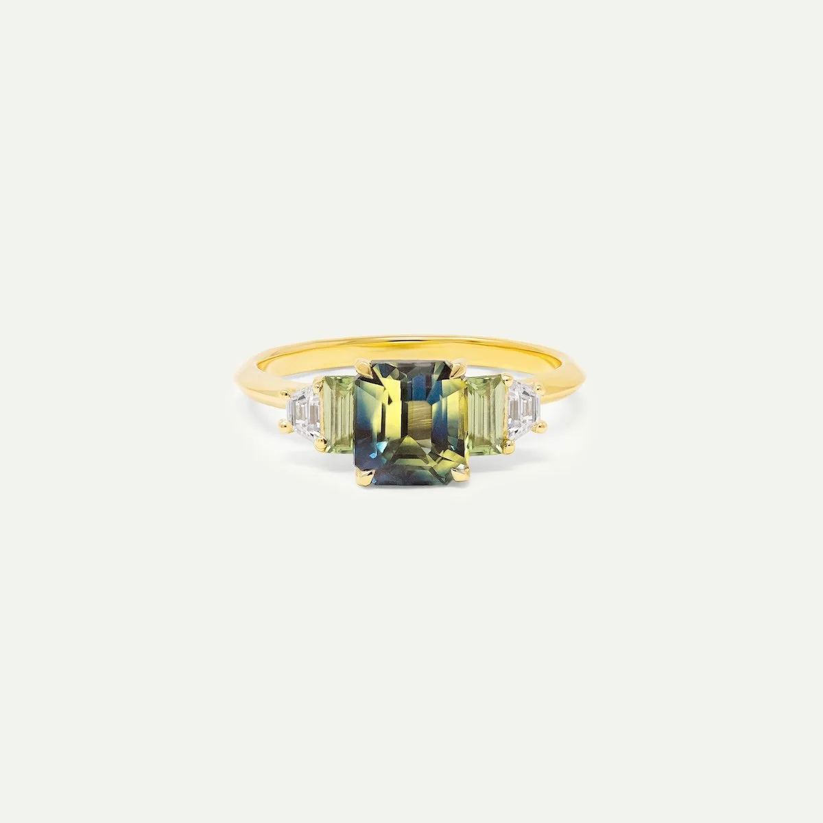 Alternative engagement ring Purvan ring in 18ct yellow gold with bi colour sapphire with mint green sapphire and trapezoid white diamonds accent stones EDXU bespoke jeweller London 