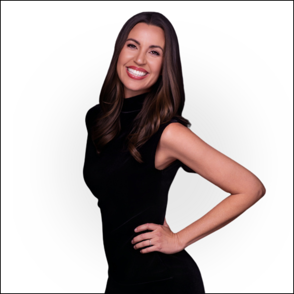 A woman with long dark hair, wearing a sleeveless black dress, smiling and posing with one hand on her hip against a white background.