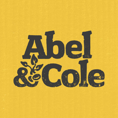 Yellow background with the text 'Abel & Cole' in bold black letters, with a small decorative floral design.
