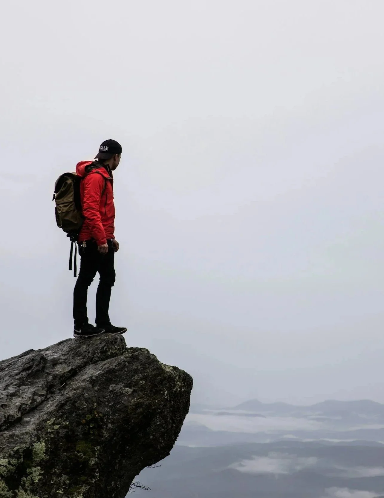 Man standing on a rock high above the land