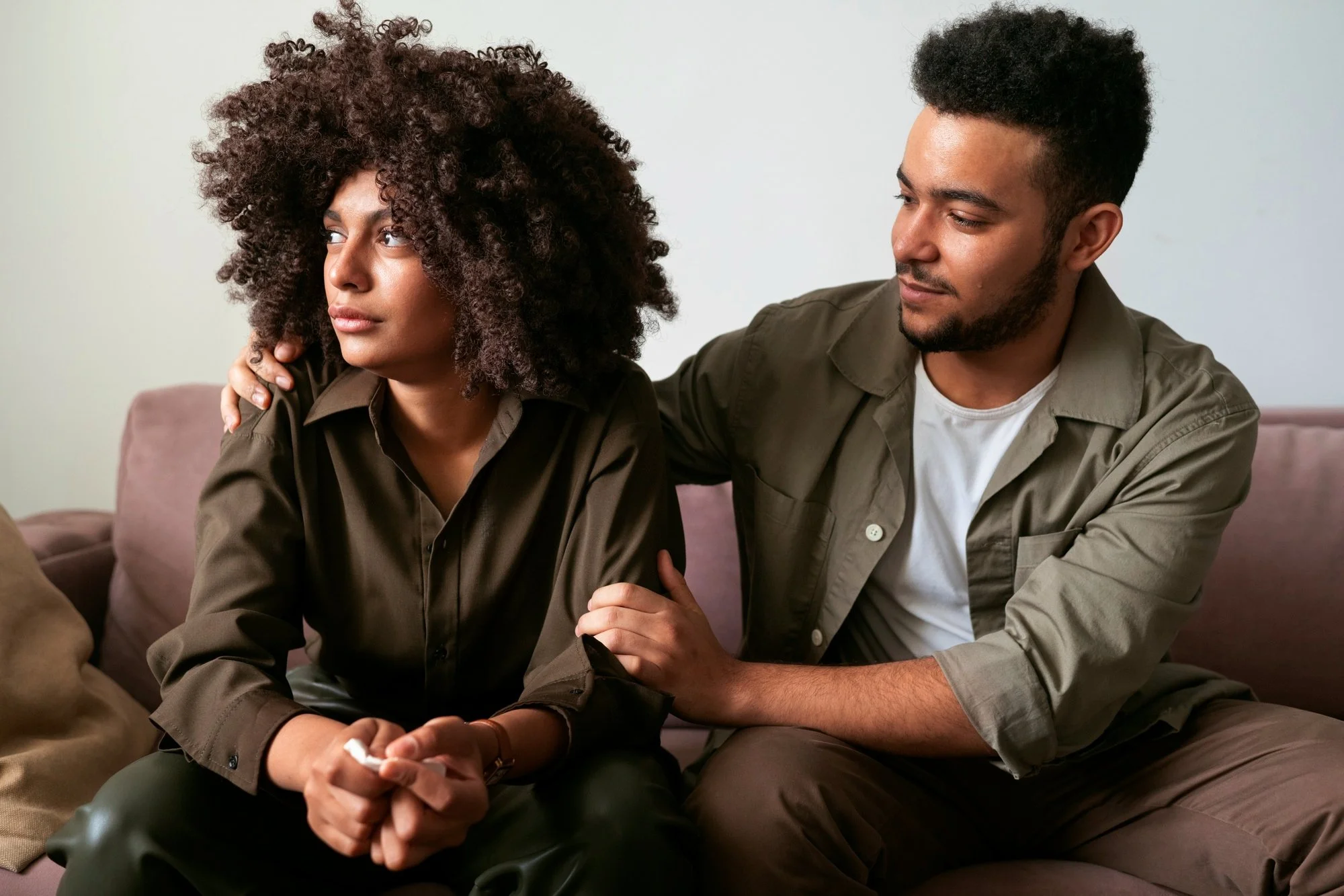 A partner listening supportively to a new mother discussing postpartum depression.