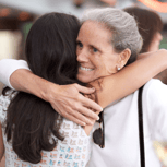 Two women hugging and smiling warmly