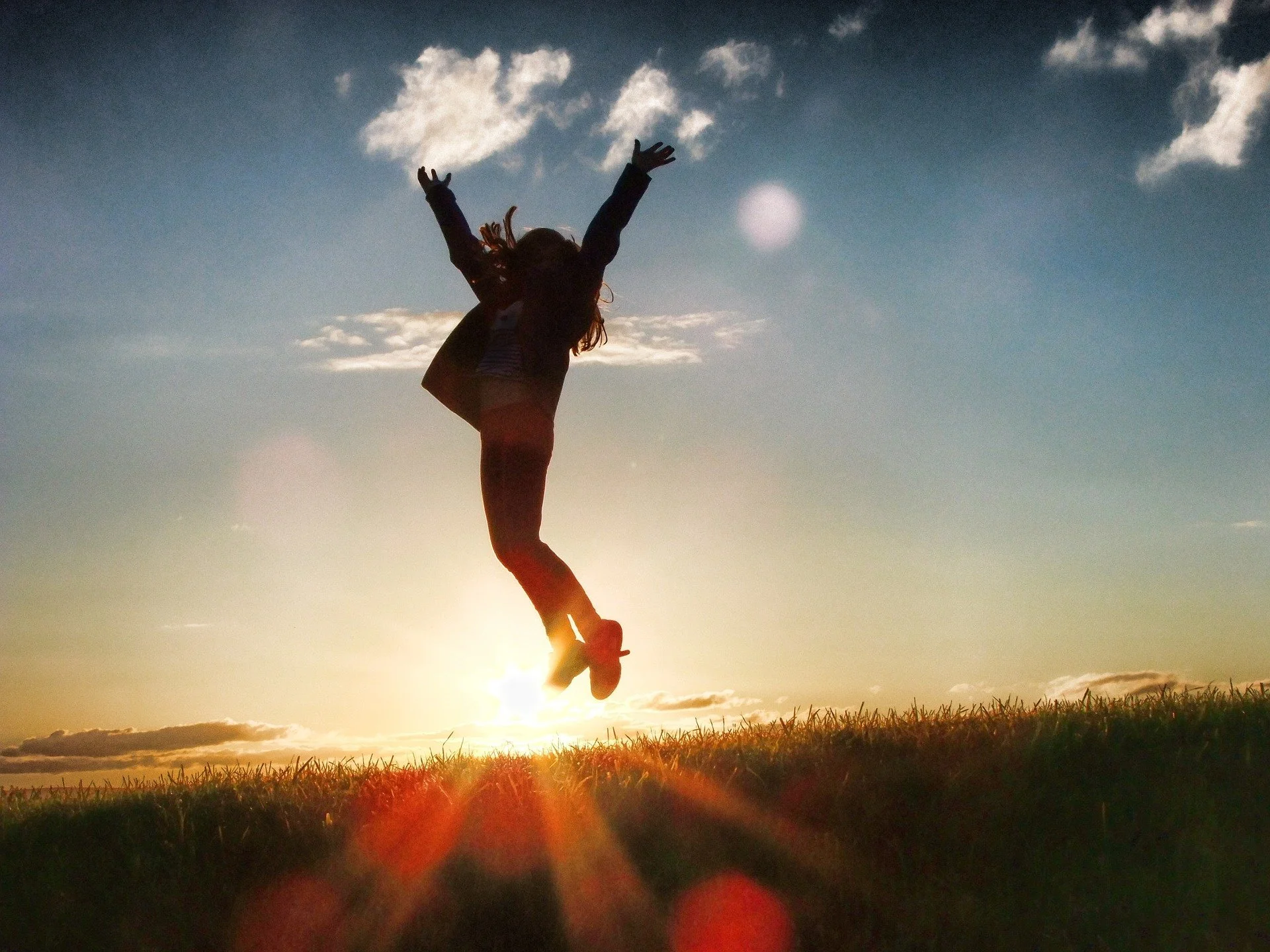 Person performing a handstand outdoors during sunset.